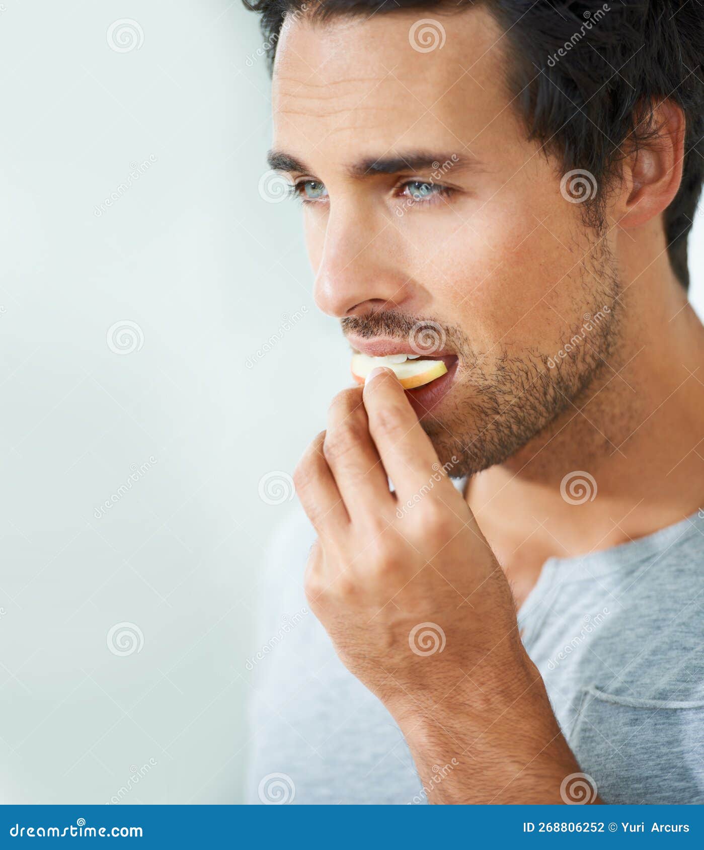 Yummy...a Handsome Young Man Eating a Slice of Apple. Stock Photo Image of lifestyle