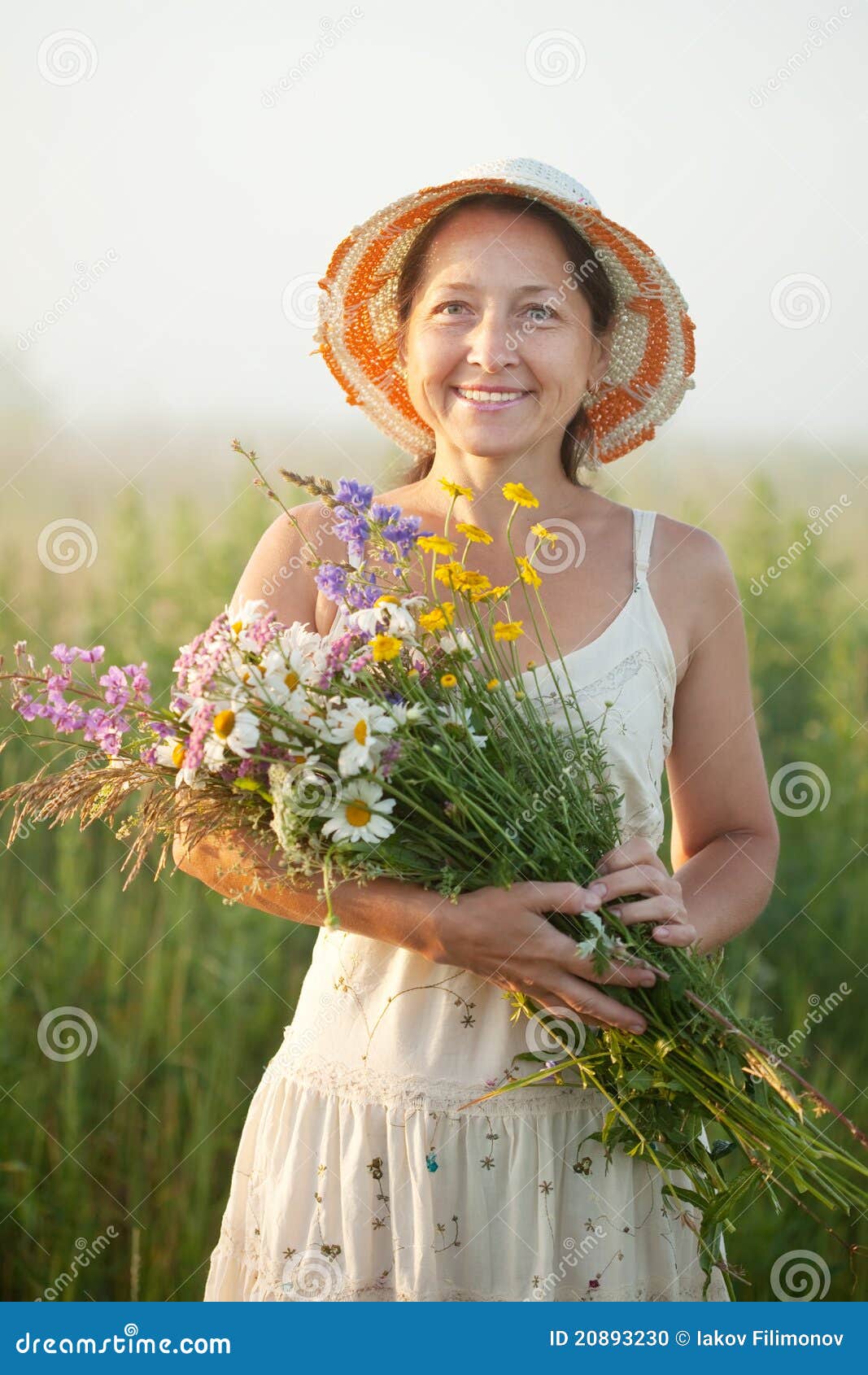 Z kwiatu posy dojrzała kobieta. Plenerowy portret dojrzała kobieta z kwiatów posy