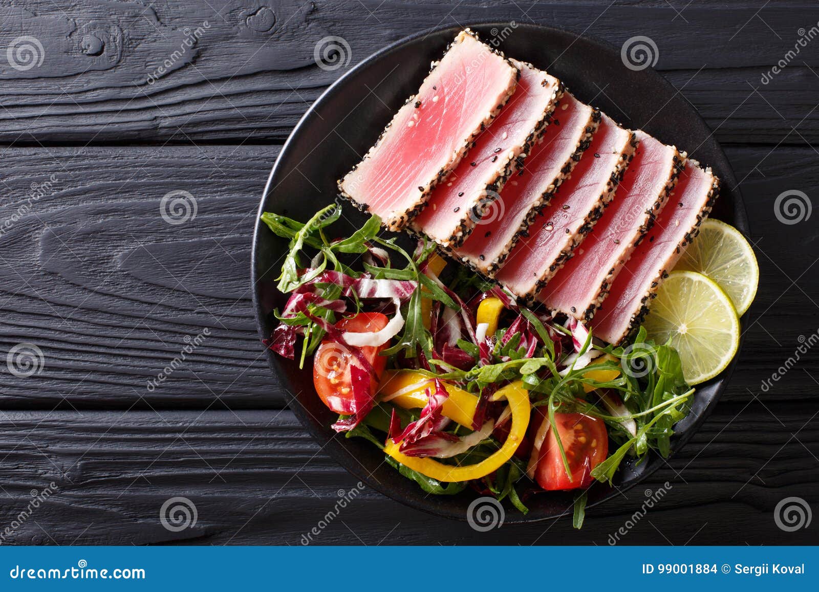 Zakończenie up rzadcy osmaleni Ahi tuńczyka plasterki z świeżego warzywa sal. Zakończenie up rzadcy osmaleni Ahi tuńczyka plasterki z świeżego warzywa sałatką na talerzu Odgórny widok od above horyzontalnego