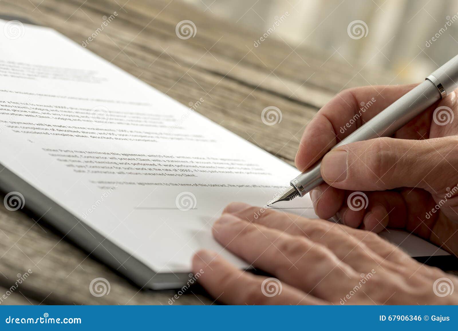 Zbliżenie podpisuje podaniową formę lub kontrakt męska ręka. Zbliżenie podpisuje kontraktacyjną lub podaniową formę z fontanny piórem na textured drewnianym biurku męska ręka