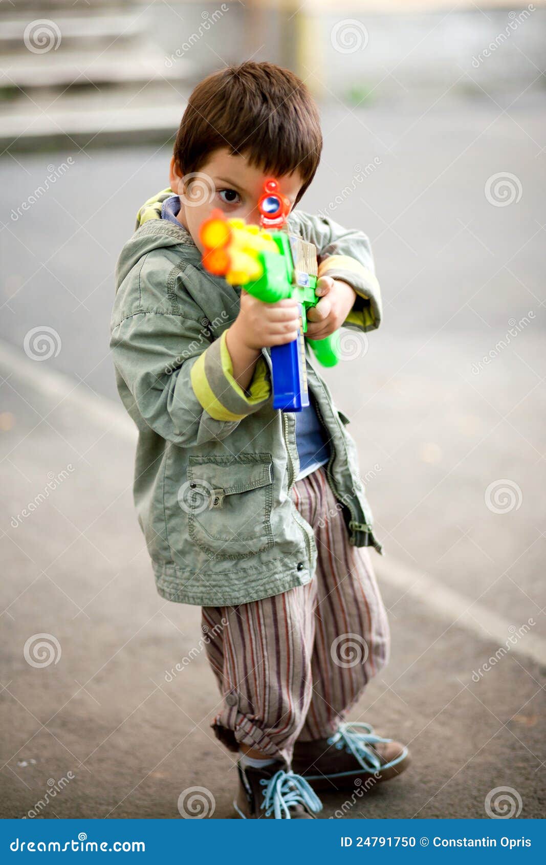 Zielen des Spielzeuggewehrs. Kind, das Spielzeuggewehr zielt. Betriebsbereites unveränderliches Feuer