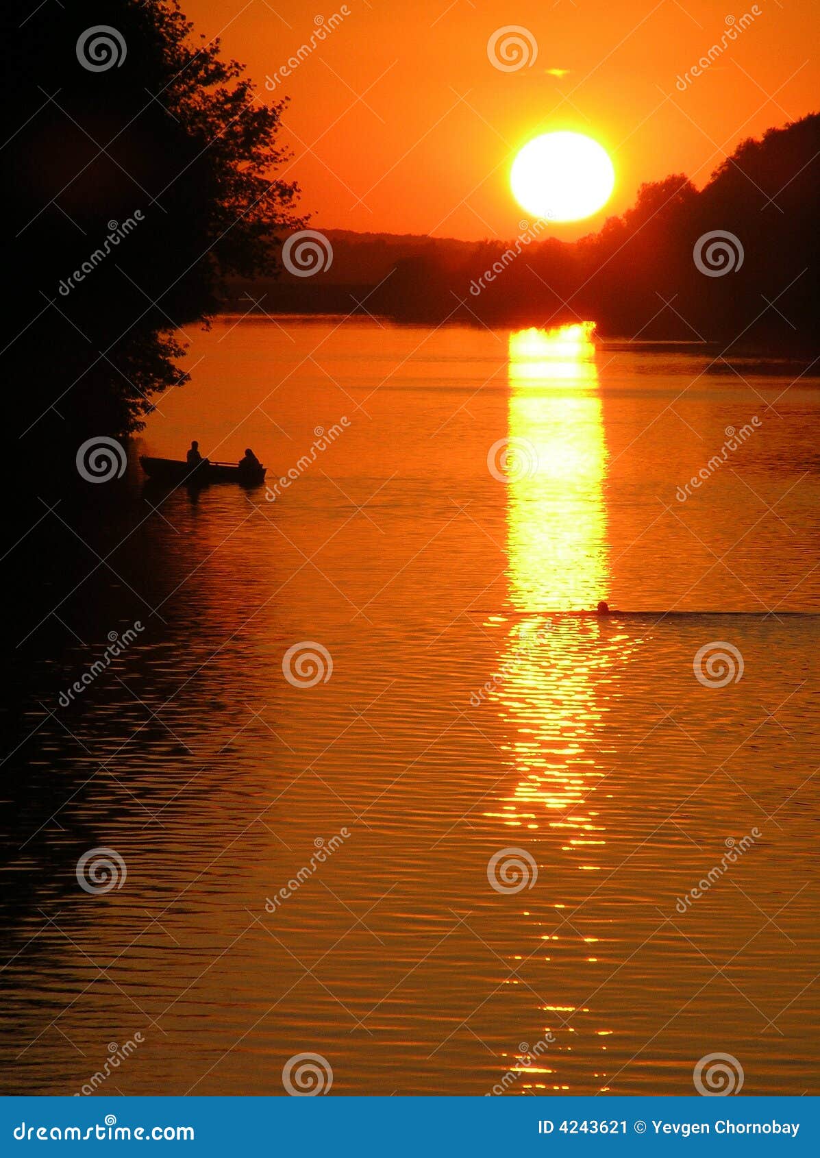 Zonsondergang op de rivier. De mensen drijven in een boot