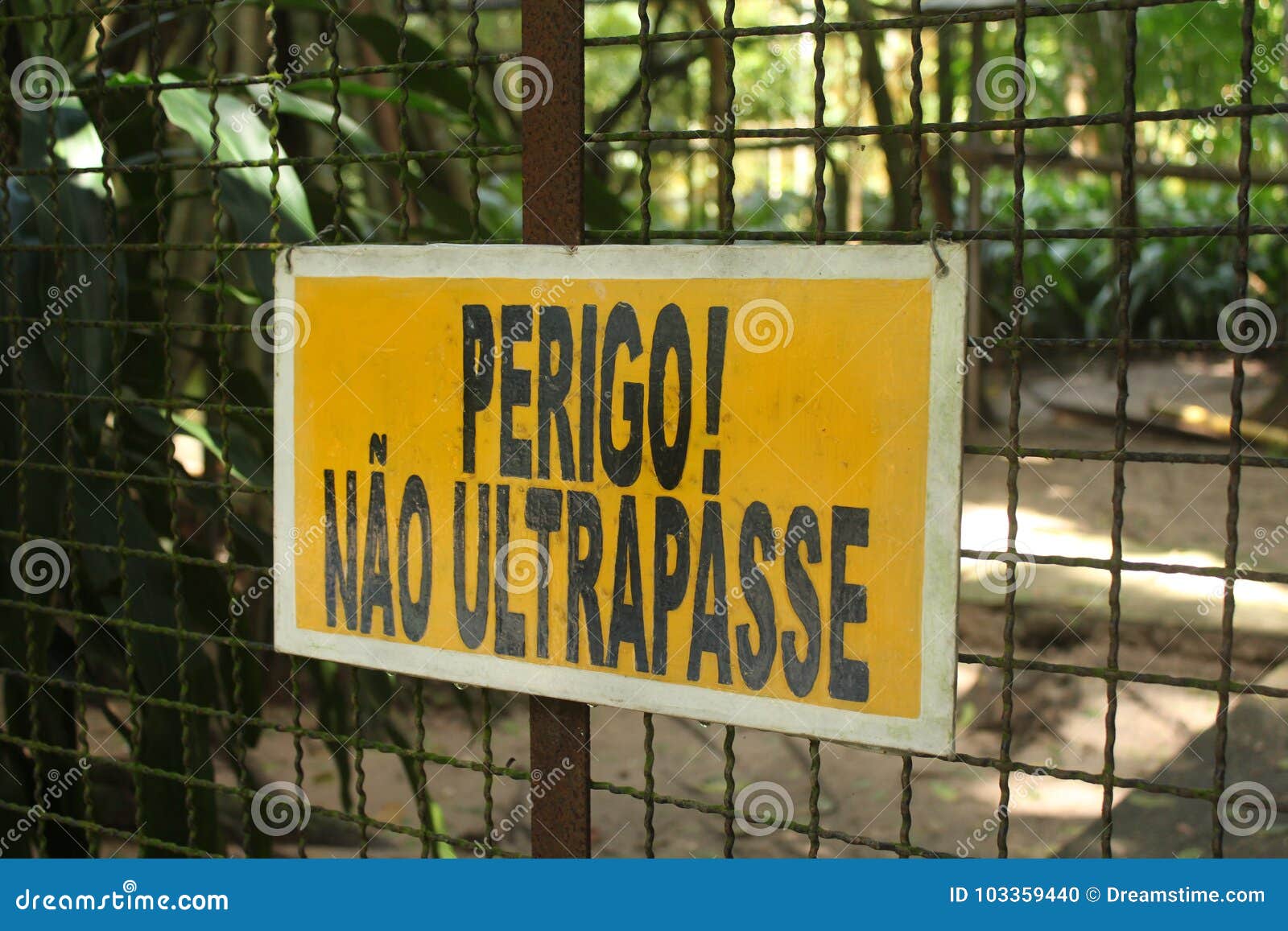 zoo yellow warning sign in portuguese: `perigo, nÃÂ£o ultrapasse!`