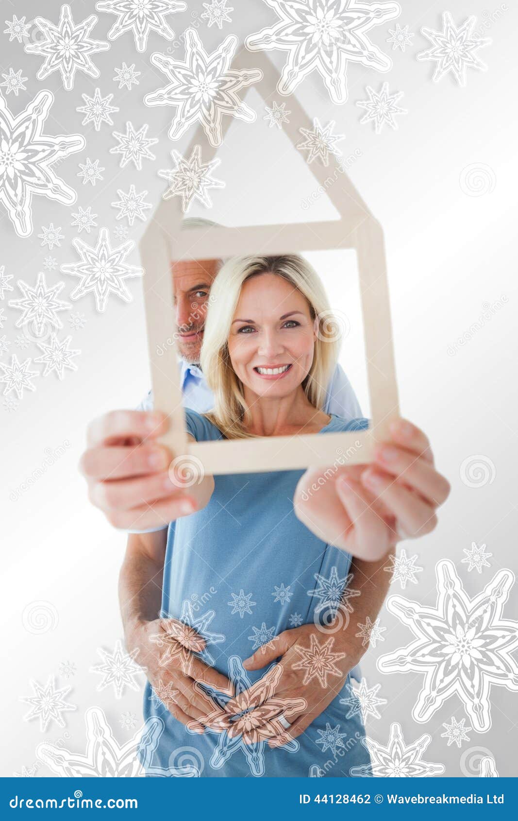 Zusammengesetztes Bild des glücklichen Paars Hausentwurf halten. Glückliches Paar, das Hausentwurf gegen Schneeflocken auf Silber hält