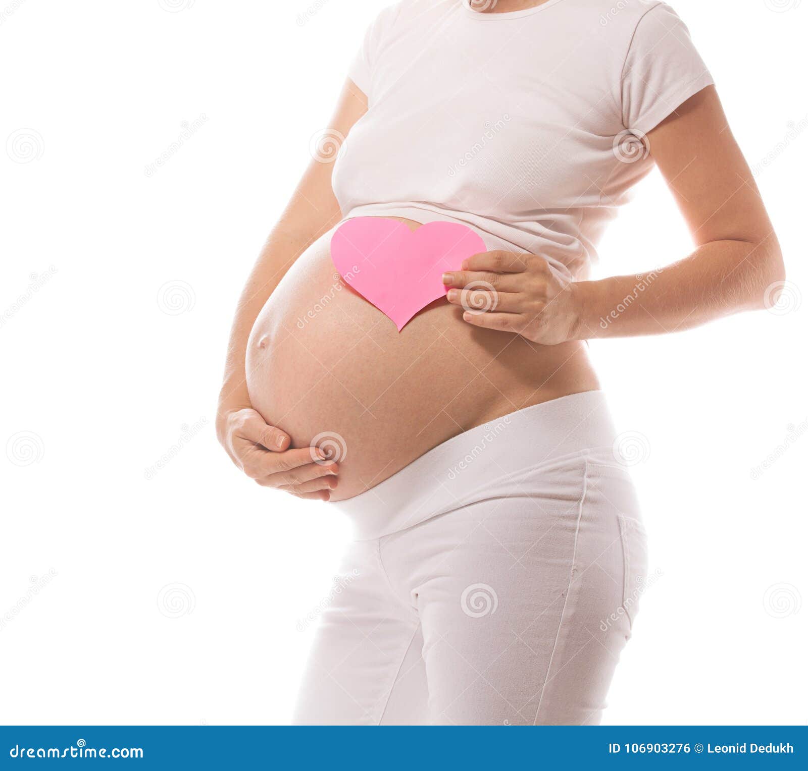 Zwangerschap. Het zwangere Kaukasische lichaam van de vrouwenclose-up solated op wit studio geschoten hart als achtergrond