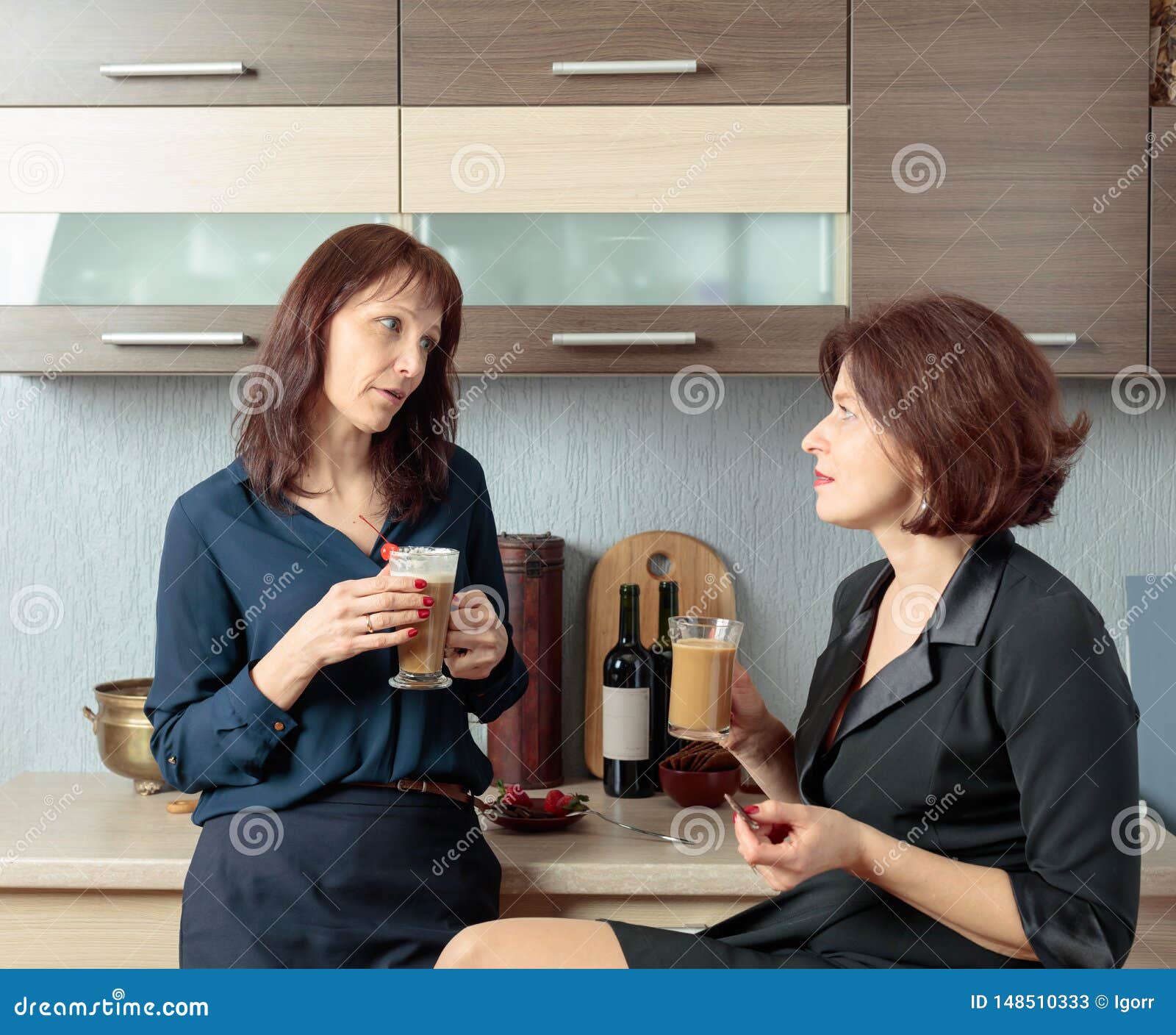 Zwei Freundinnen Sprechen Und Trinken Kaffee  In Der K  che  