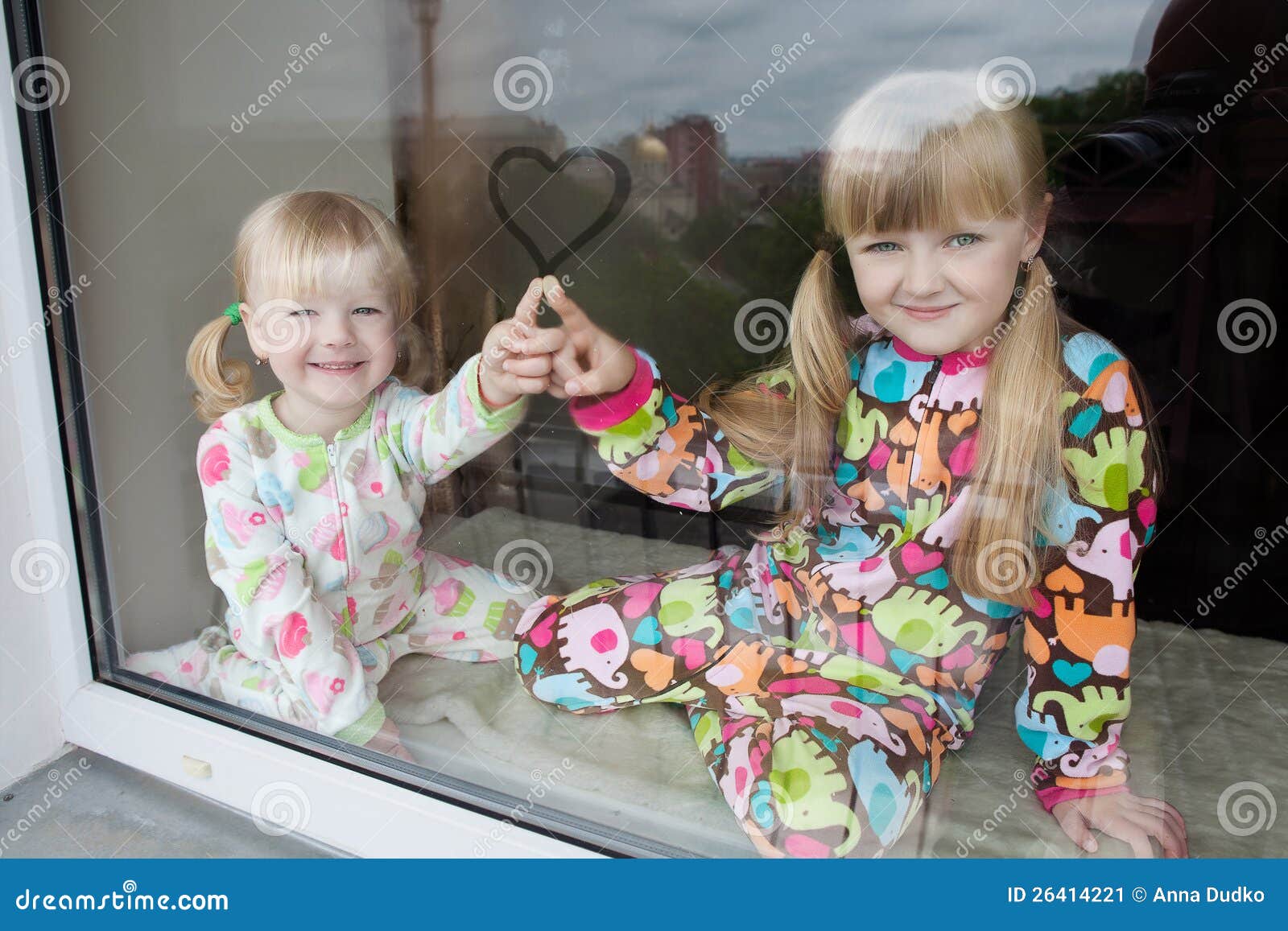Spiel mit zwei Mädchen am Fensterrahmen in den Schlafanzügen vor Schlaf