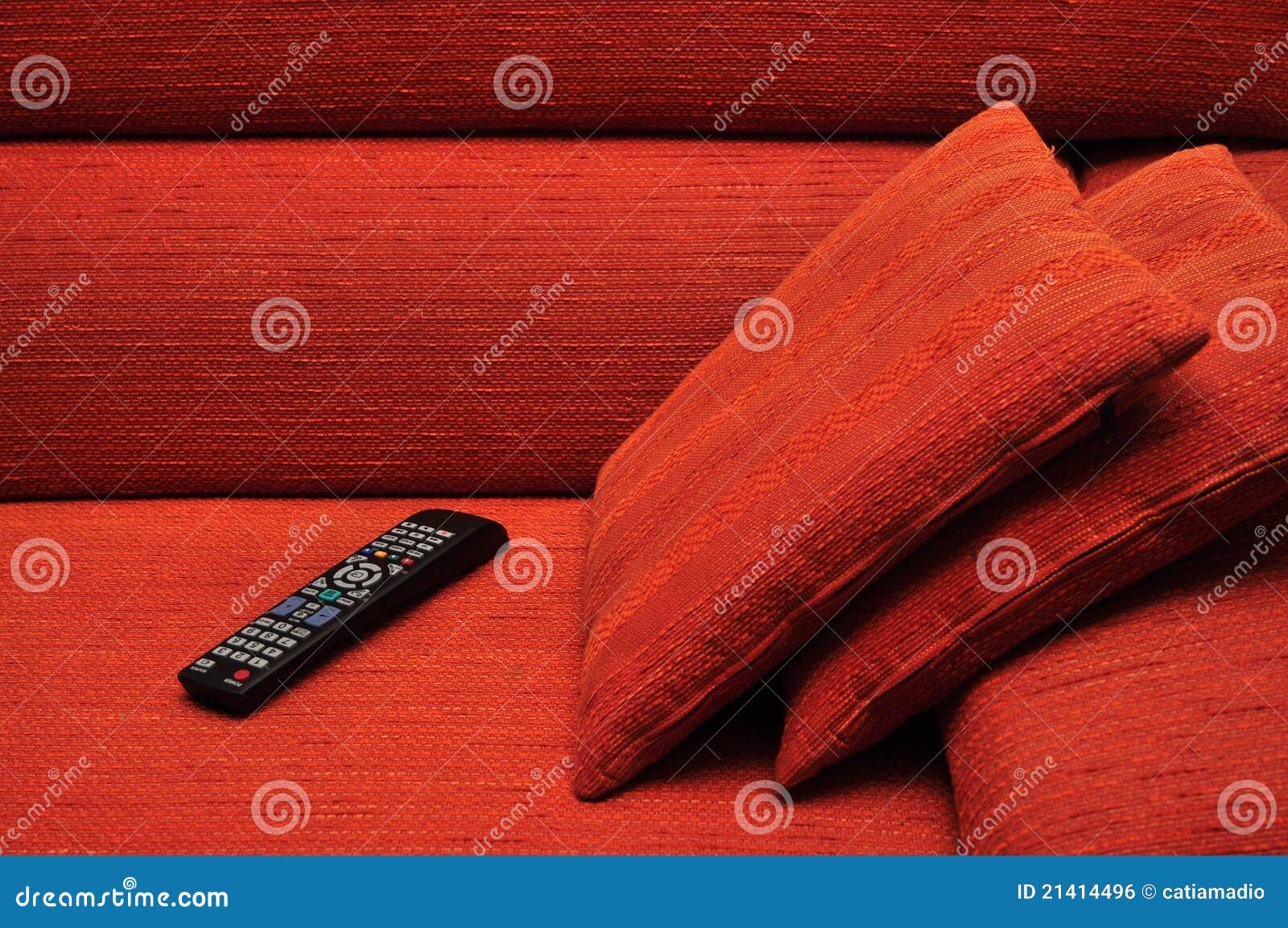 À télécommande sur le sofa. TV à télécommande sur le sofa orange