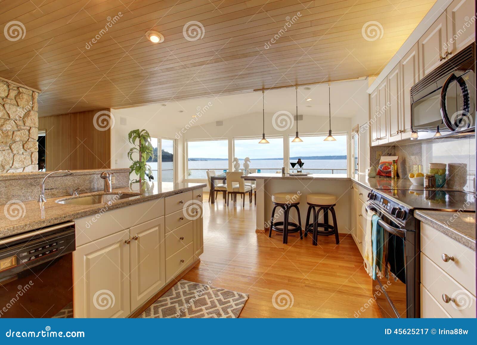 Área de la cocina con el techo y el suelo de parqué artesonados. Interior de la casa El sitio de la cocina con el techo artesonado, los gabinetes blancos con granito remata Vista del comedor brillante con la cubierta de la huelga