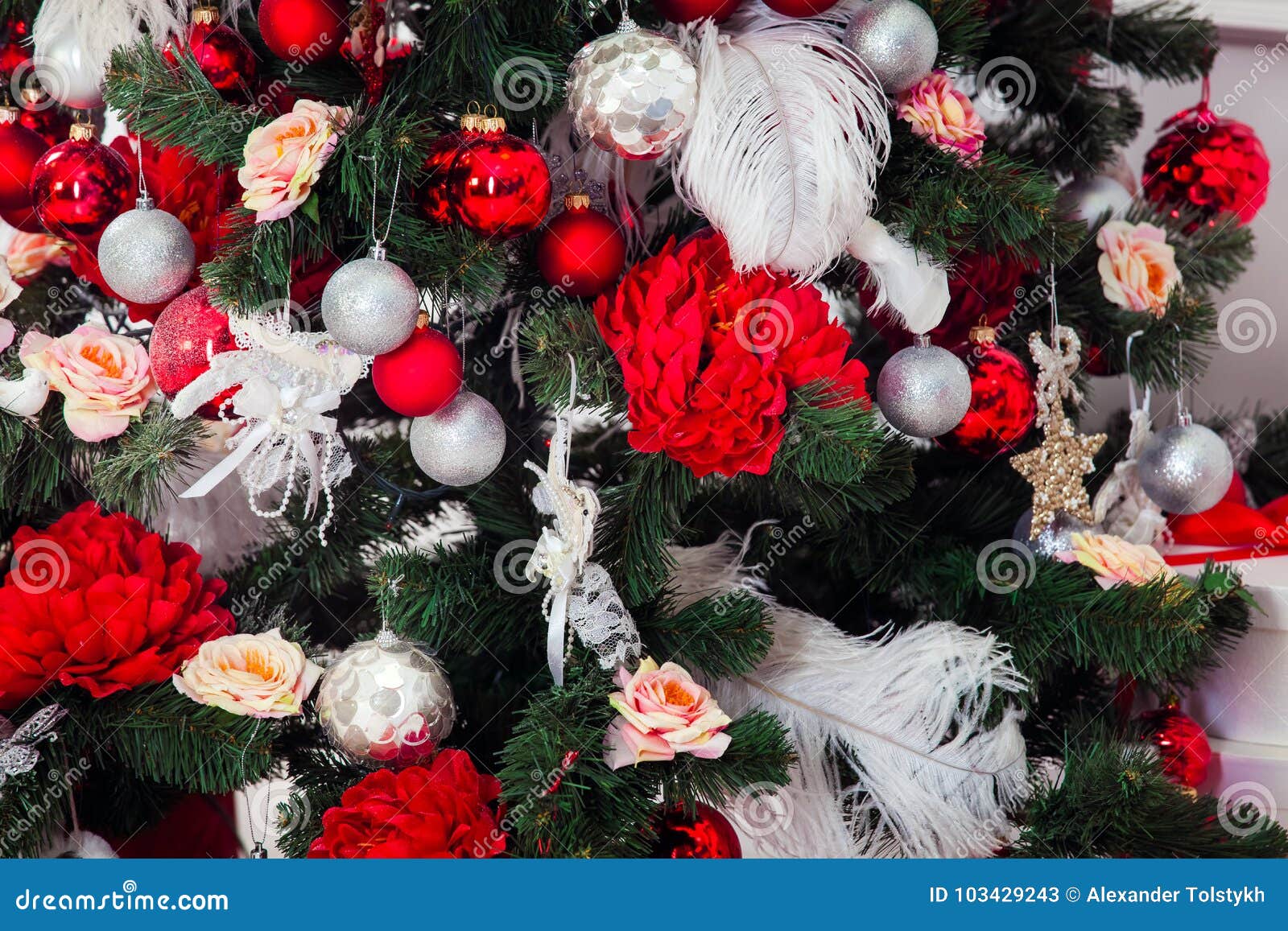 Árvore verde do ano novo decorada com brinquedos, as bolas e as flores vermelhos Fundo do Natal