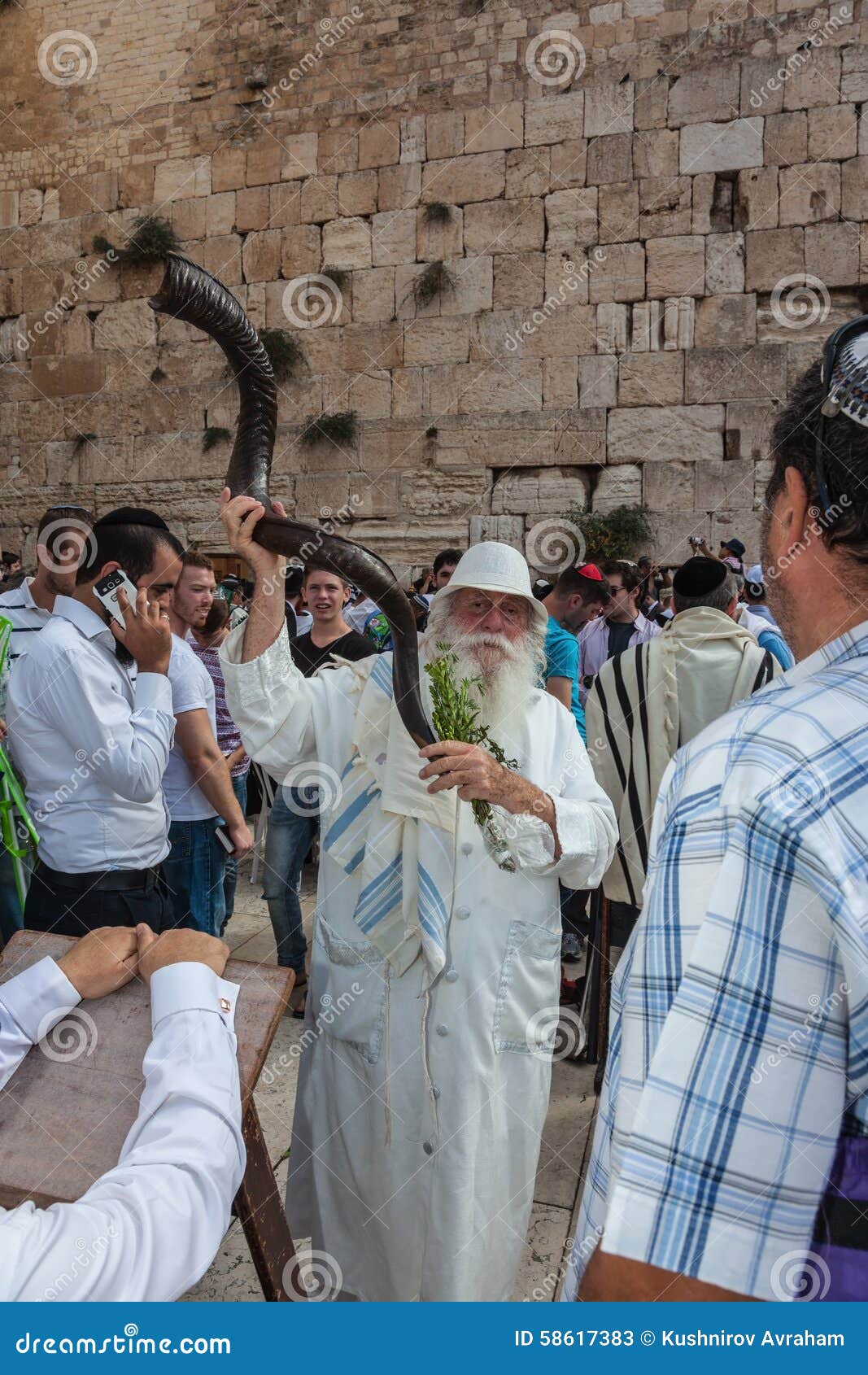 Älterer Jude mit einem Shofar. JERUSALEM, ISRAEL - 12. OKTOBER 2014: Morgenherbst Sukkot Der Bereich vor Klagemauer des Tempels füllte mit Leuten Älterer religiöser Jude mit einem Shofar