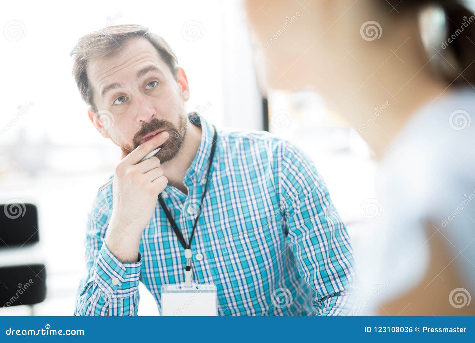 Écouter l'agent. Jeune homme d'affaires songeur regardant son client ou collègue pendant la discussion des questions principales