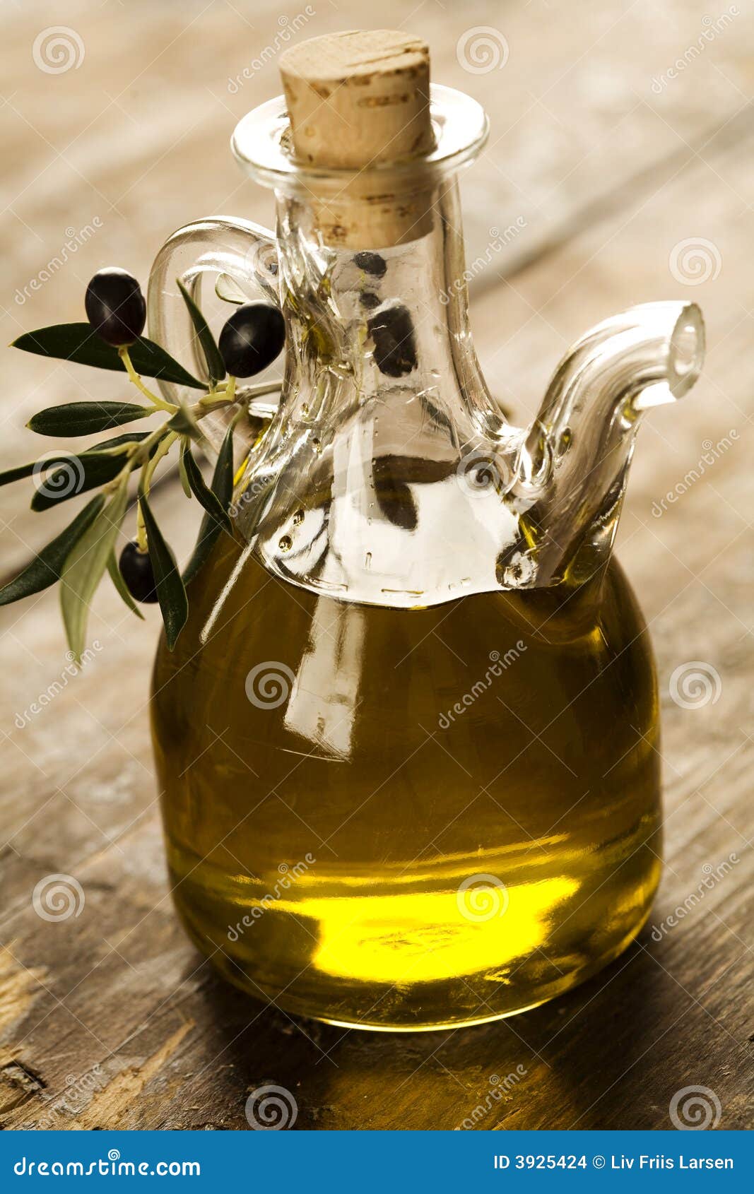 Ölivenöl. Flasche Olivenöl auf alter hölzerner Tabelle und einem Ölzweig