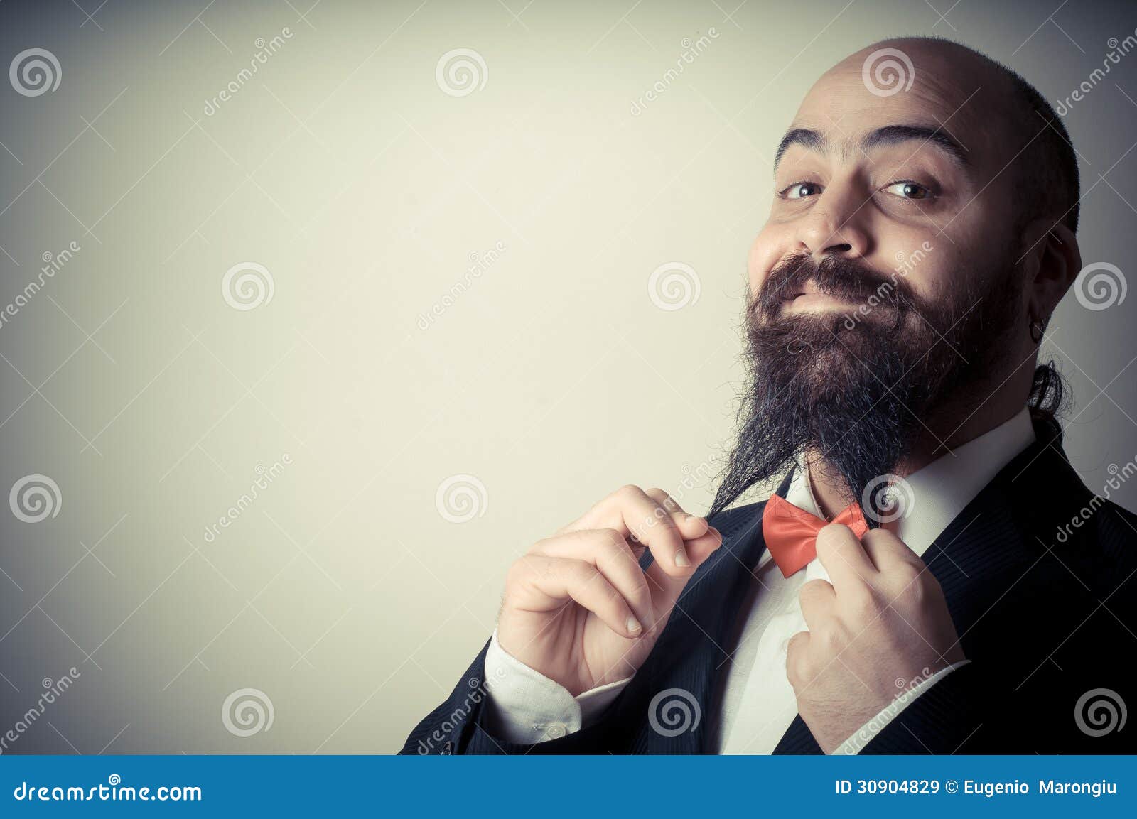 Śmiesznego eleganckiego brodatego mężczyzna wzruszająca broda na vignetting tle