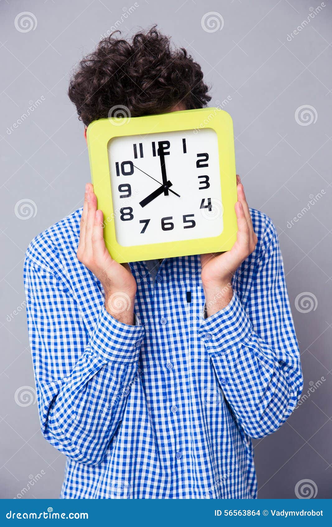 Άτομο που καλύπτει το πρόσωπό του με το μεγάλο ρολόι