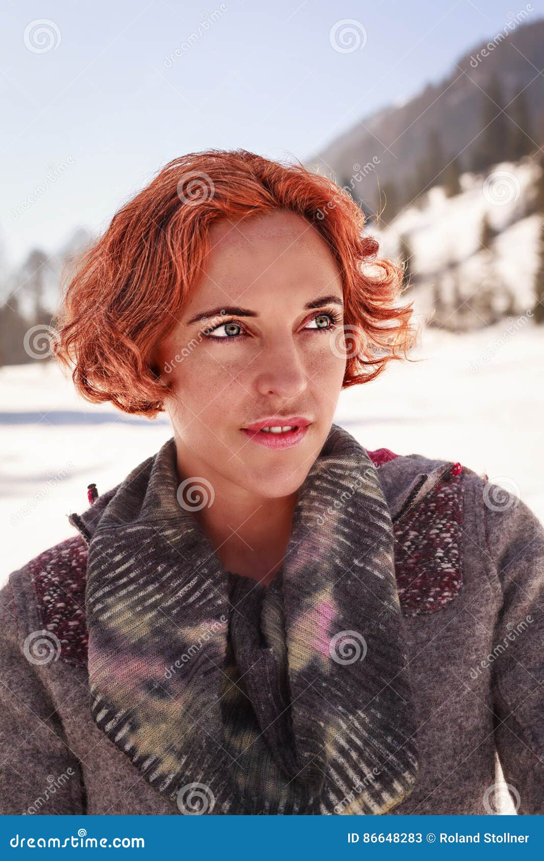 Απολαμβάνει το χειμερινό καιρό. Πορτρέτο κινηματογραφήσεων σε πρώτο πλάνο μιας κοκκινομάλλους γυναίκας που χαμογελά με το χειμερινό υπόβαθρο