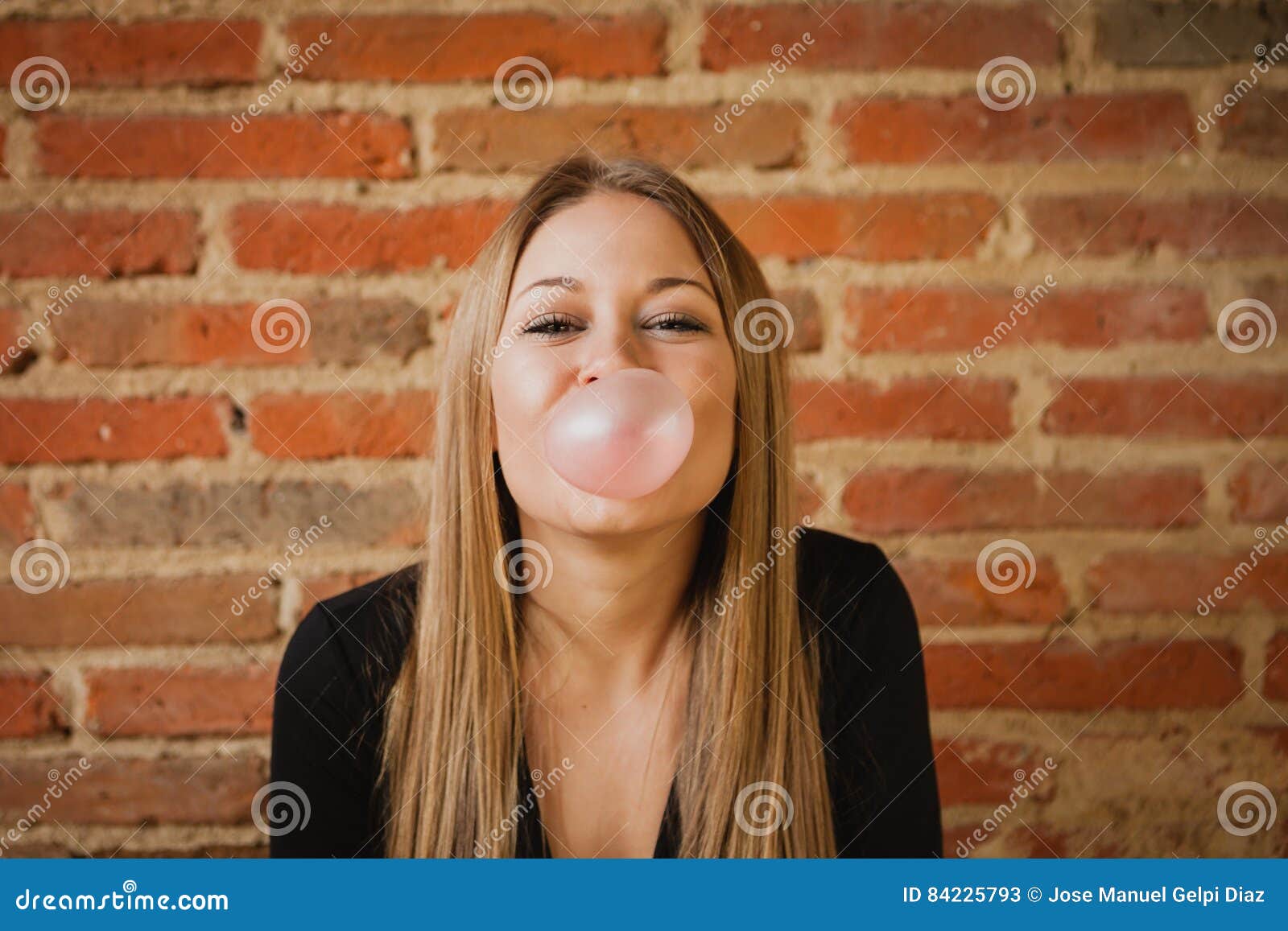 Αστείο κορίτσι που κάνει pomp με μια γόμμα φυσαλίδων. Αστείο κορίτσι που κατασκευάζει pomp με μια γόμμα φυσαλίδων και έναν τουβλότοιχο του υποβάθρου