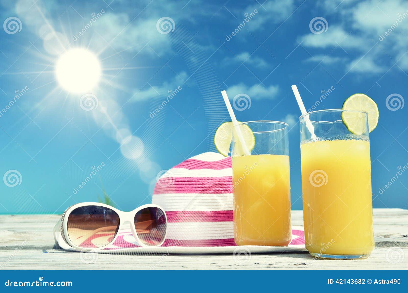 Γυαλιά ηλίου, καπέλο και χυμός από πορτοκάλι