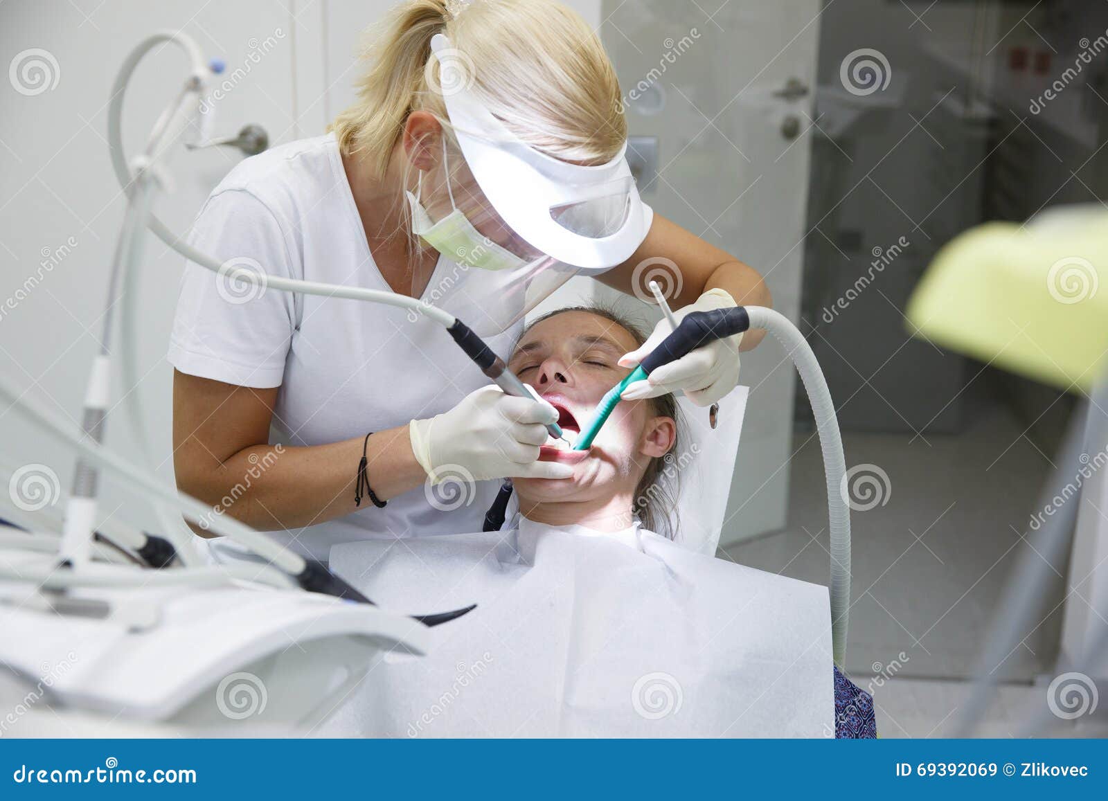 Γυναίκα στο οδοντικό γραφείο, οδοντίατρος που εξετάζει και που καθαρίζει τα δόντια της ταρτάρου και πινακίδας, που αποτρέπουν την περιοδοντική ασθένεια Οδοντική υγιεινή, επίπονες διαδικασίες και έννοια πρόληψης