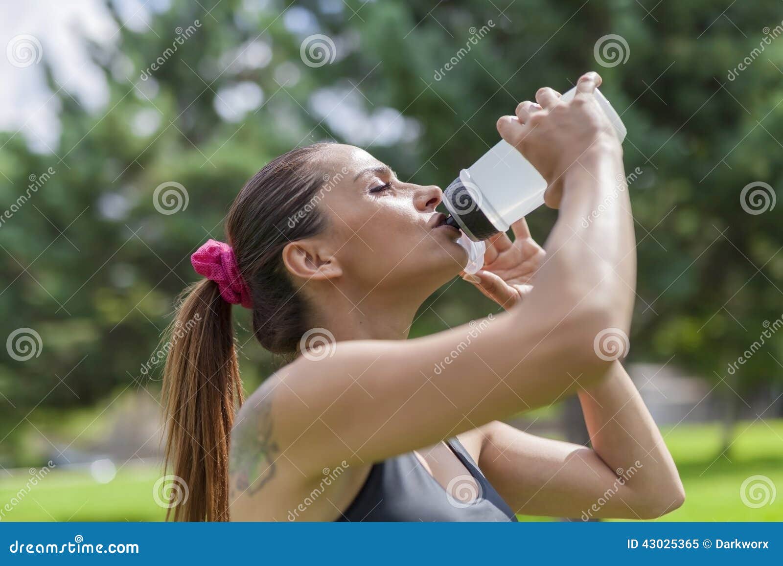 Διψασμένο νέο πόσιμο νερό γυναικών στηργμένος. Φωτογραφία κινηματογραφήσεων σε πρώτο πλάνο του πόσιμου νερού γυναικών στηργμένος Υπάρχει εκλεκτική εστίαση στο πρότυπο