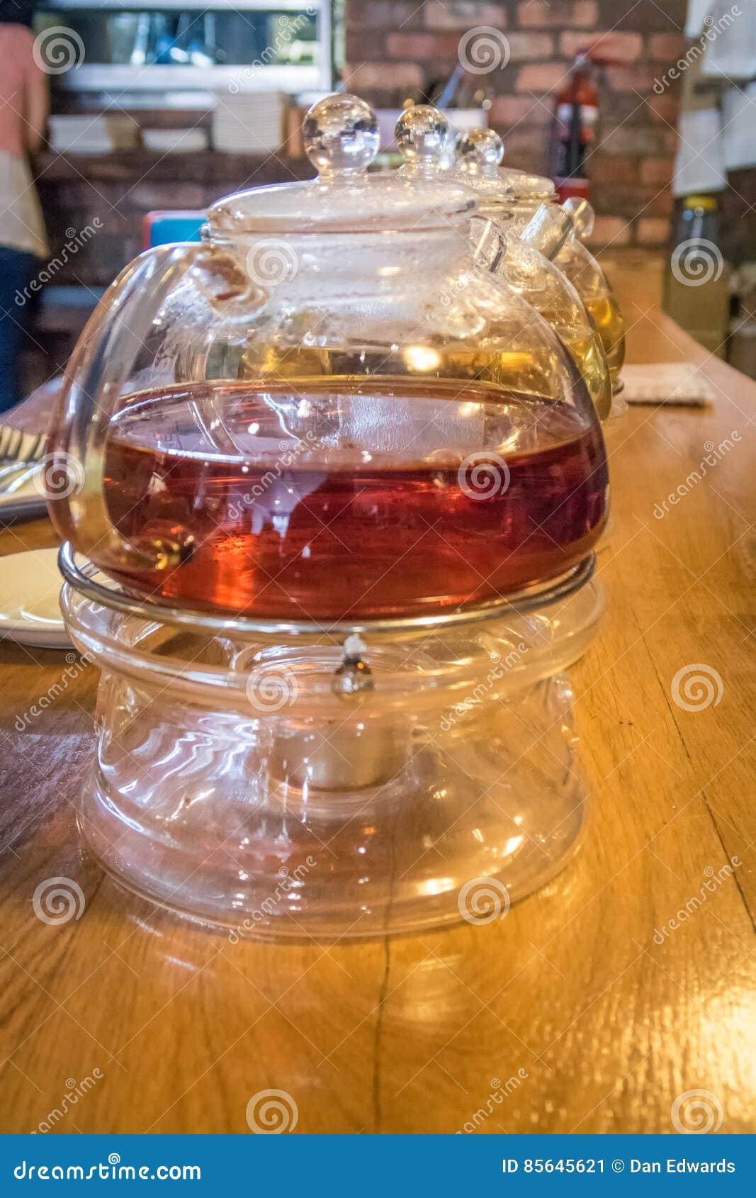 Δοχεία τσαγιού. Teapot γυαλιού Tradditinal του μαύρου τσαγιού σε έναν καφέ