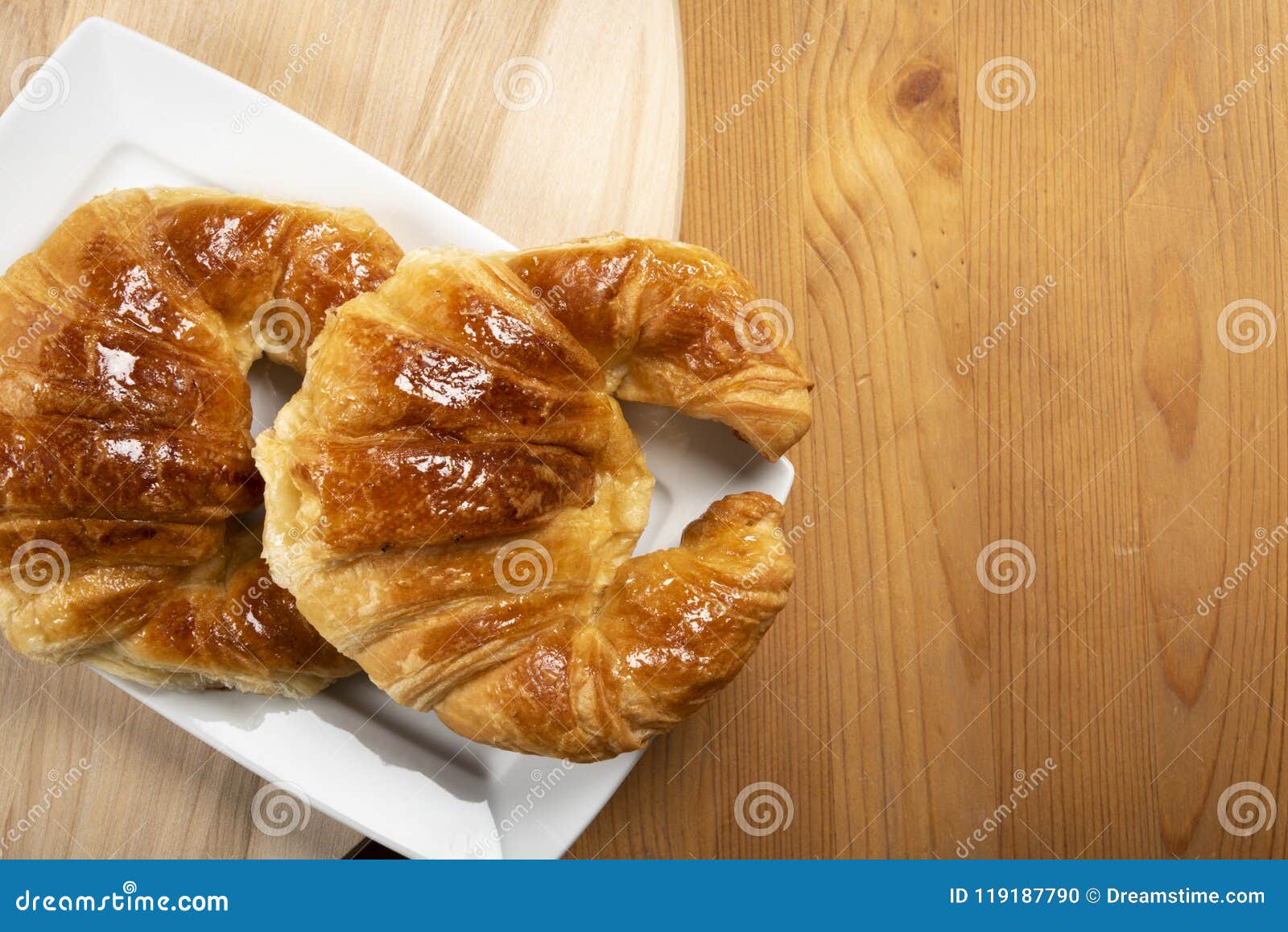 Δύο croissants για το πρόγευμα. Δύο croissant στην άσπρη τοπ άποψη πιάτων