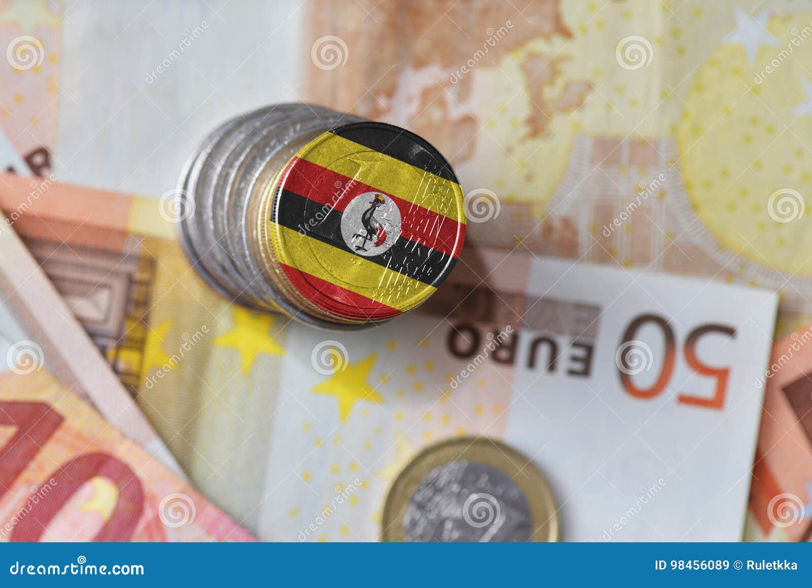 Ευρο- νόμισμα με τη εθνική σημαία της Ουγκάντας στο ευρο- υπόβαθρο τραπεζογραμματίων χρημάτων χρηματοδότηση αυγών σιτηρεσίου έννοιας ανασκόπησης χρυσή