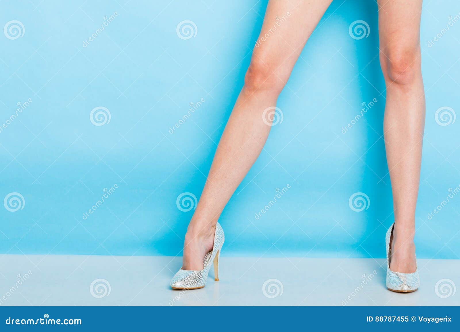 Θηλυκά πόδια στα ασημένια υψηλά παπούτσια τακουνιών. Θηλυκή μόδα Τα ασημένια υψηλά τακούνια κάρφωσαν τα μοντέρνα παπούτσια στα προκλητικά μακριά πόδια Στούντιο που πυροβολείται ενάντια στο μπλε