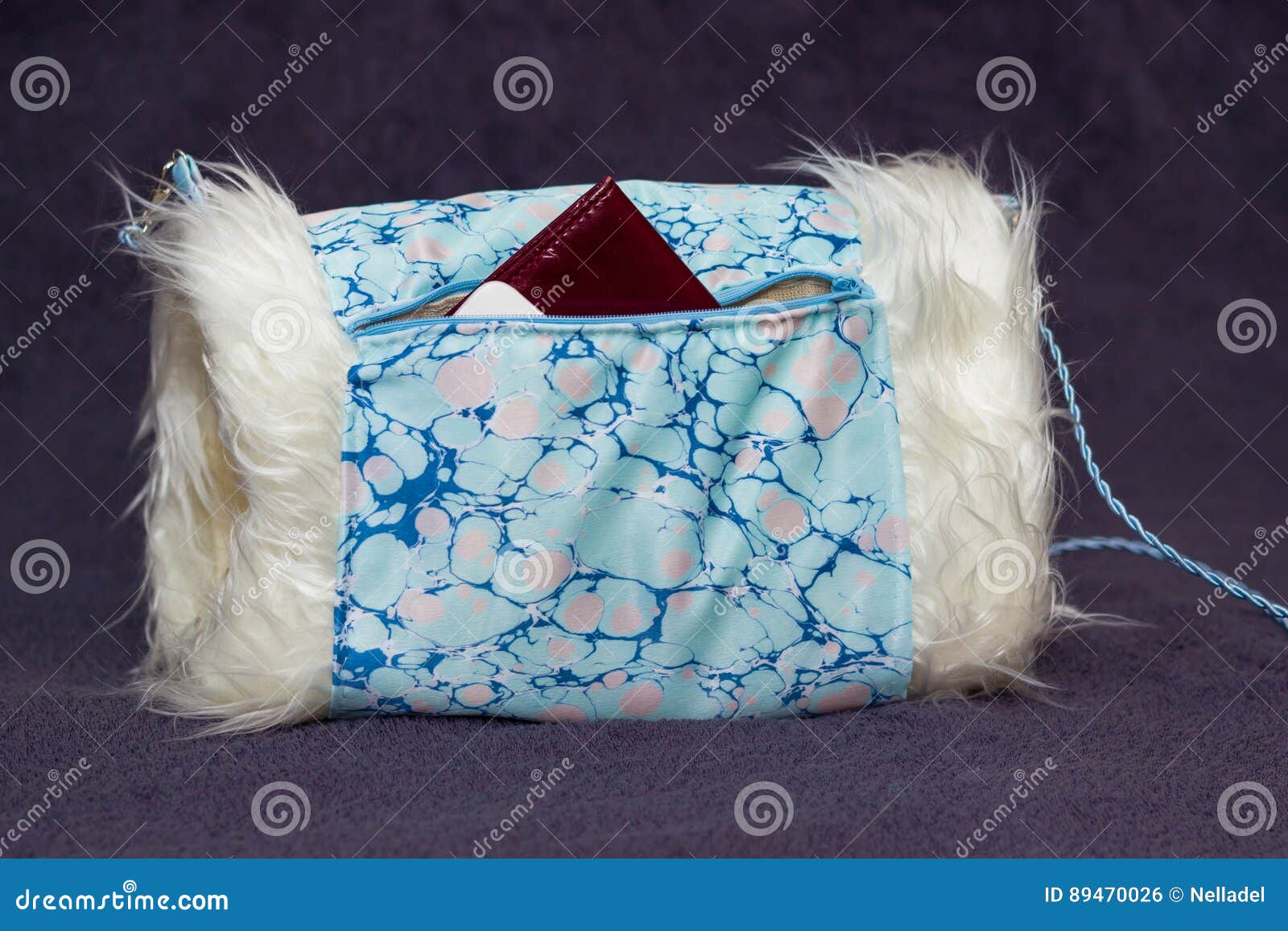 Κάλυμμα με μια τσέπη. Χειροποίητο συνθετικό άσπρο κάλυμμα γουνών με την μπλε περιποίηση υφάσματος ebru με ένα διαβατήριο που κολλά από την τσέπη του στο γκρίζο ρηχό βάθος υποβάθρου του τομέα