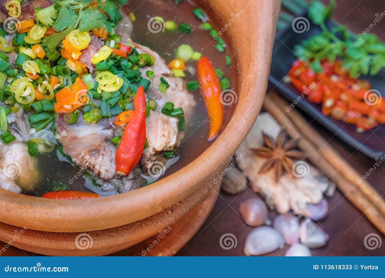 καυτή και πικάντικη σούπα χοιρινού κρέατος με τα τσίλι χορταριών σε μια αγγειοπλαστική