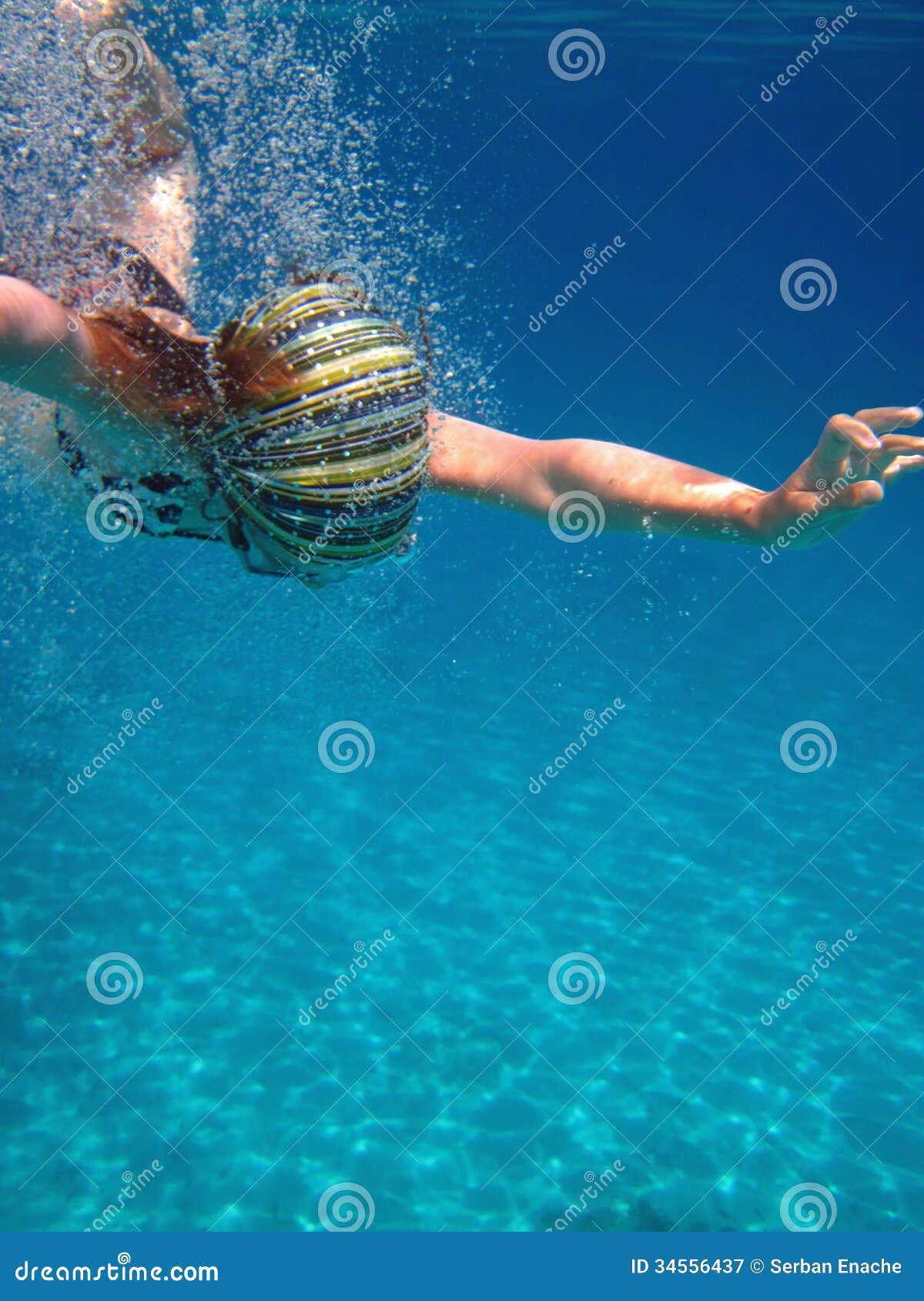 Κολύμβηση κοριτσιών υποβρύχια. Κολύμβηση κοριτσιών που καταδύεται στο σαφές, μπλε νερό.