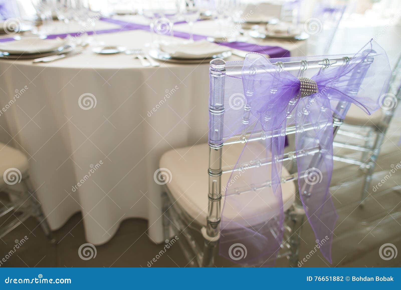 Κομψός πίνακας που τίθεται στο λεπτό εστιατόριο. Άσπρος εξυπηρετούμενος πίνακας σε ένα εστιατόριο σε έναν γαμήλιο εορτασμό Ασημένια μαχαιροπήρουνα, πιάτο, γυαλιά σε ένα άσπρο τραπεζομάντιλο με τις ιώδεις κορδέλλες