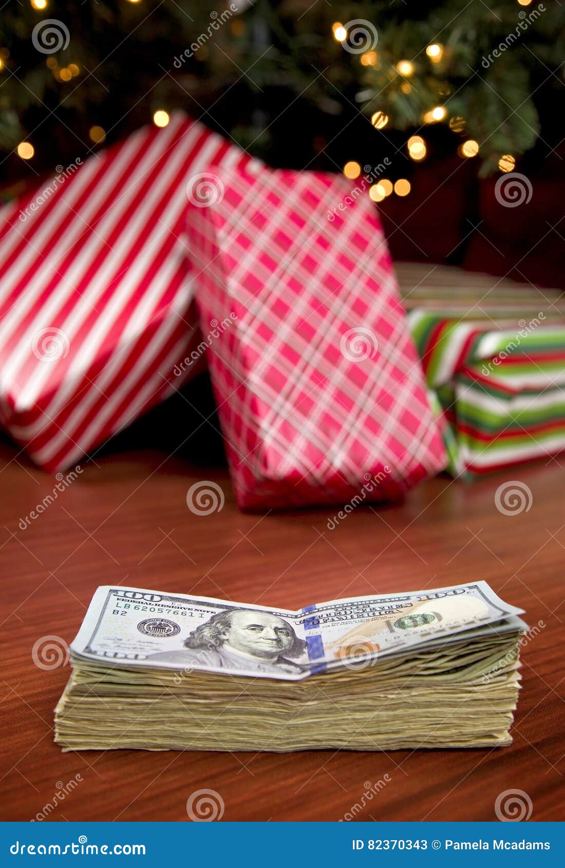 Κόστος των Χριστουγέννων. Ένας σωρός των χρημάτων μπροστά από ένα χριστουγεννιάτικο δέντρο