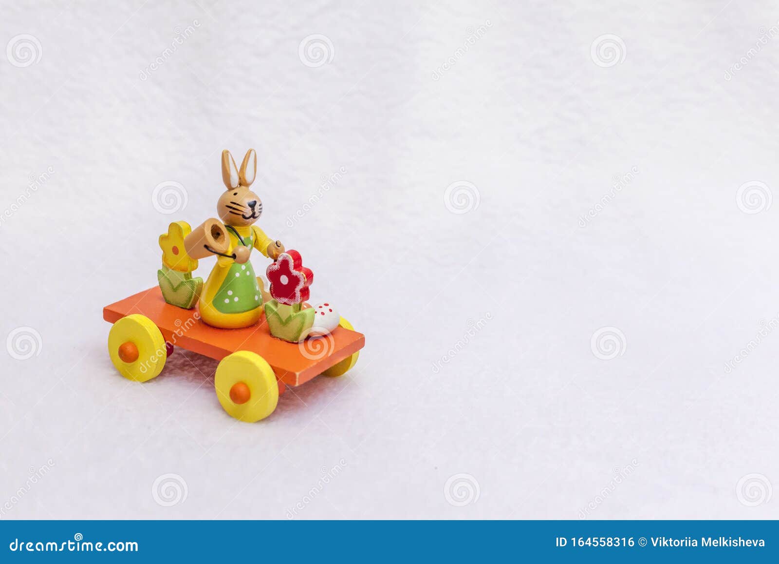 Λαγουδάκι του Πάσχα στο τρένο με ένα αυγό, έναν κουβά και λουλούδια της άνοιξης - ένα ξύλινο παιχνίδι μεταφοράς, ένα φωτεινό πορτ. Λαγουδάκι του Πάσχα στο τρένο με αυγό, κουβά και ελατήρια - ένα ξύλινο παιχνίδι μεταφοράς, ένα φωτεινό πορτοκαλί, κίτρινο, κόκκινο και πράσινο, μια πλατφόρμα με τροχούς από το ρυμουλκούμενο Χαριτωμένη φωτογραφία με χώρο αντιγραφής