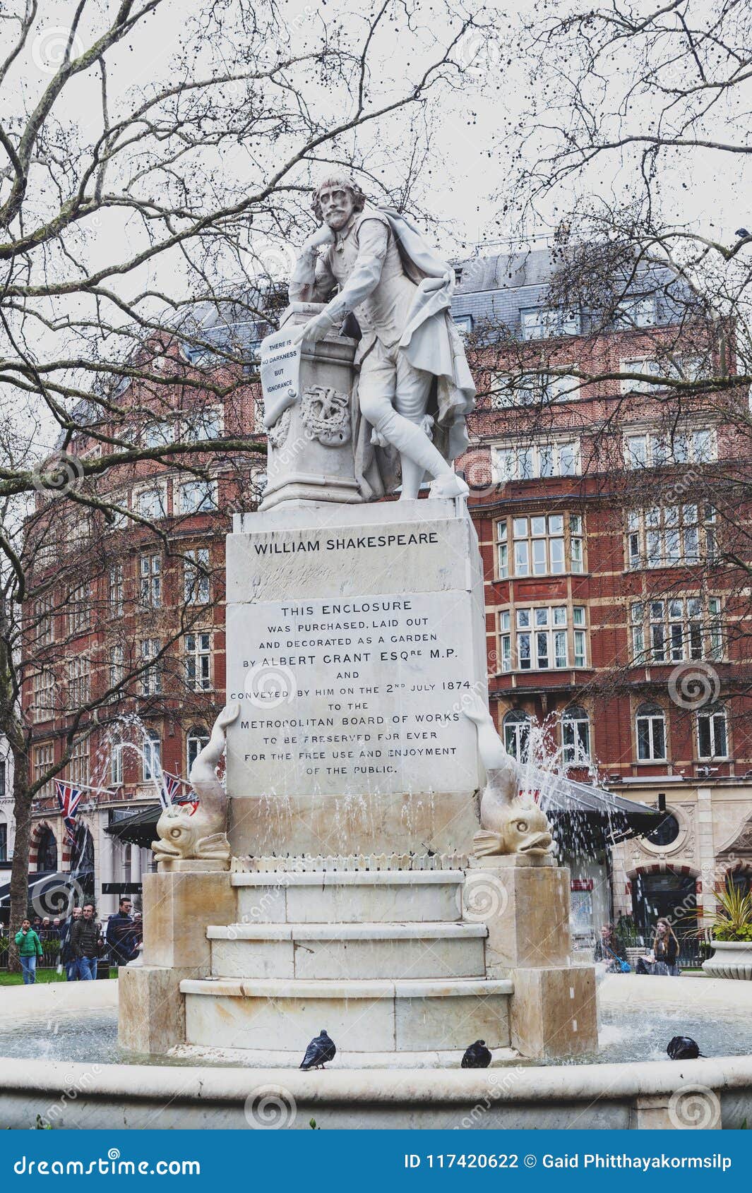 Μαρμάρινο άγαλμα του William Shakespeare τετραγωνικός κήπος Λέιτσεστερ στο Λονδίνο, Ηνωμένο Βασίλειο. Λονδίνο, UK - τον Απρίλιο του 2018: Η πηγή Shakespeare και το μαρμάρινο άγαλμα του William Shakespeare περιέβαλαν από τα δελφίνια, γλυπτά από το Giovanni Fontana, που βρέθηκε στο μικρό πάρκο στους τετραγωνικούς κήπους Λέιτσεστερ πόλη του Γουέστμινστερ, Λονδίνο, Ηνωμένο Βασίλειο