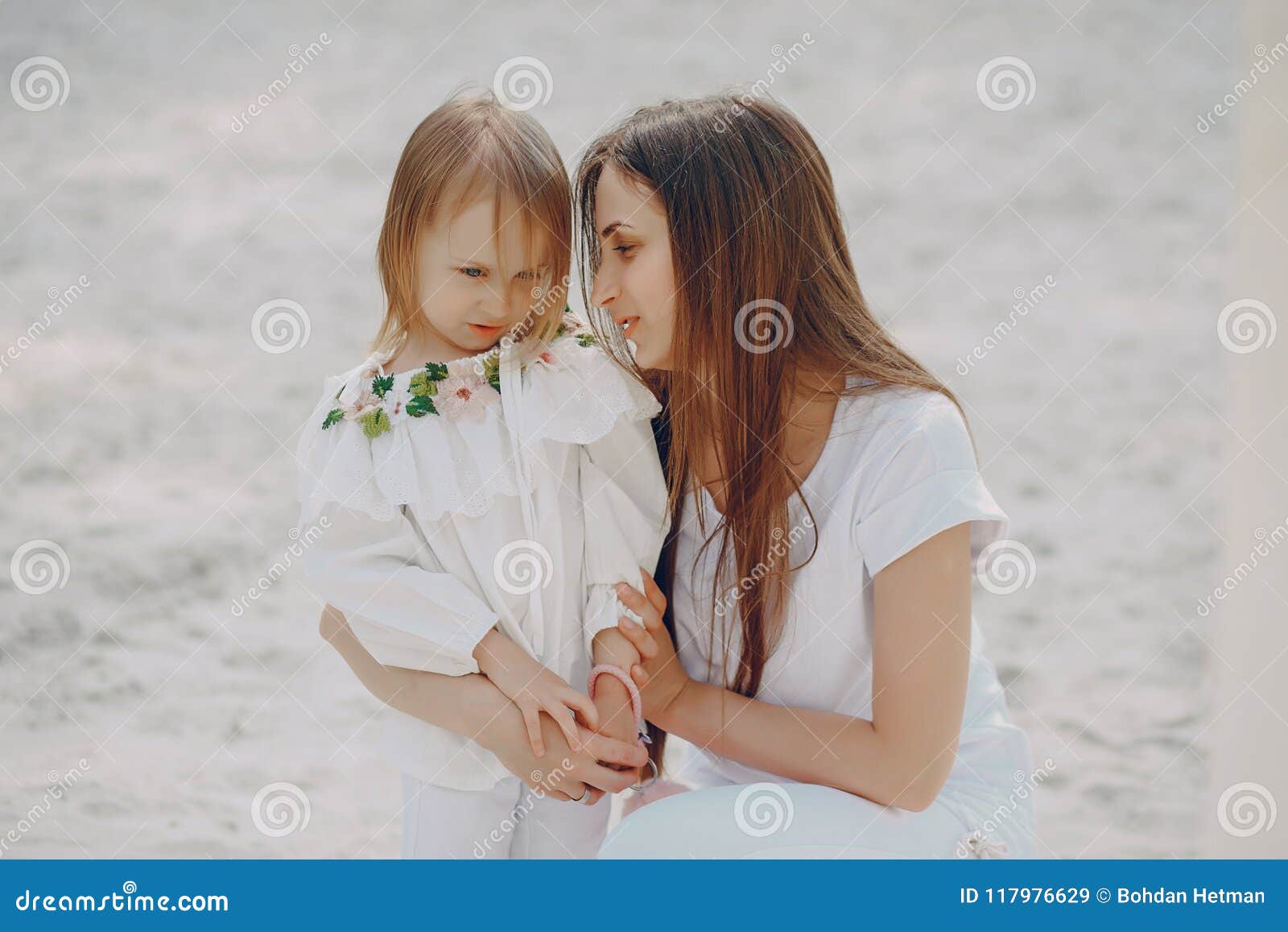 Μητέρα με τις κόρες. Παιχνίδια όμορφα νέα μητέρων στην παραλία με την λίγη κόρη