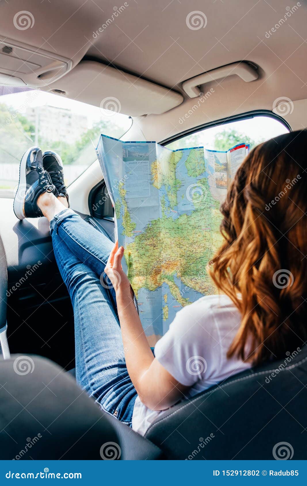 Νέα γυναίκα που παίρνει έτοιμη να ταξιδεψει με το αυτοκίνητο και που κοιτάζει στο χάρτη