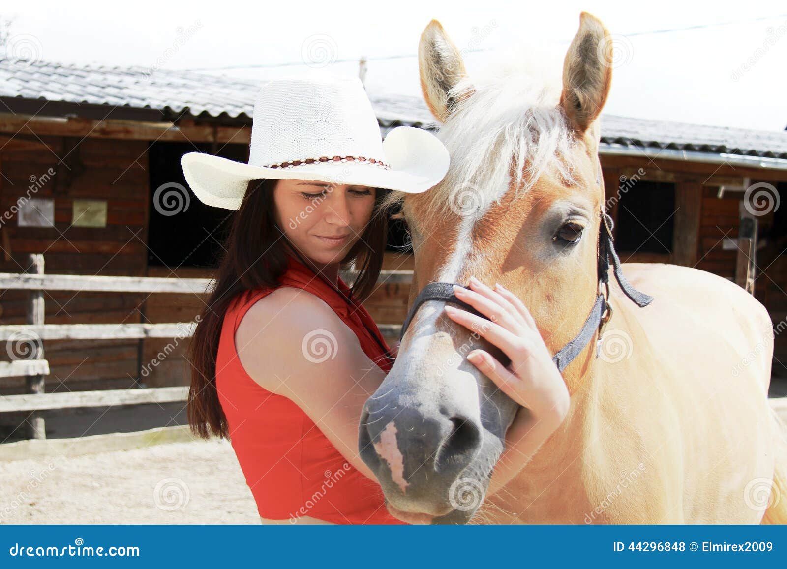Νέα γυναίκα που φροντίζει το άλογό της. Φωτογραφία της νέας γυναίκας που φροντίζει το άλογό της