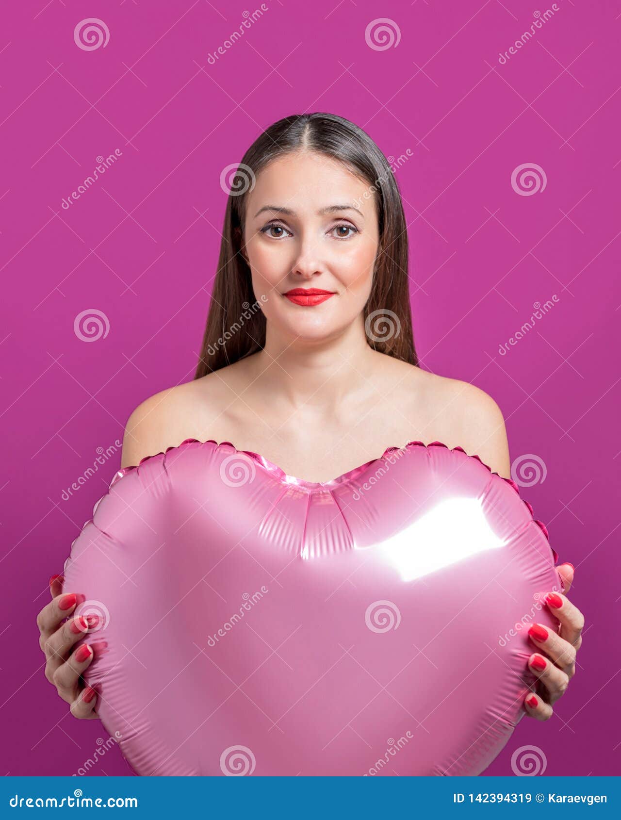 Νέα όμορφη γυναίκα που κρατά ένα διαμορφωμένο καρδιά μπαλόνι αέρα Έννοια ημέρας βαλεντίνων ` s