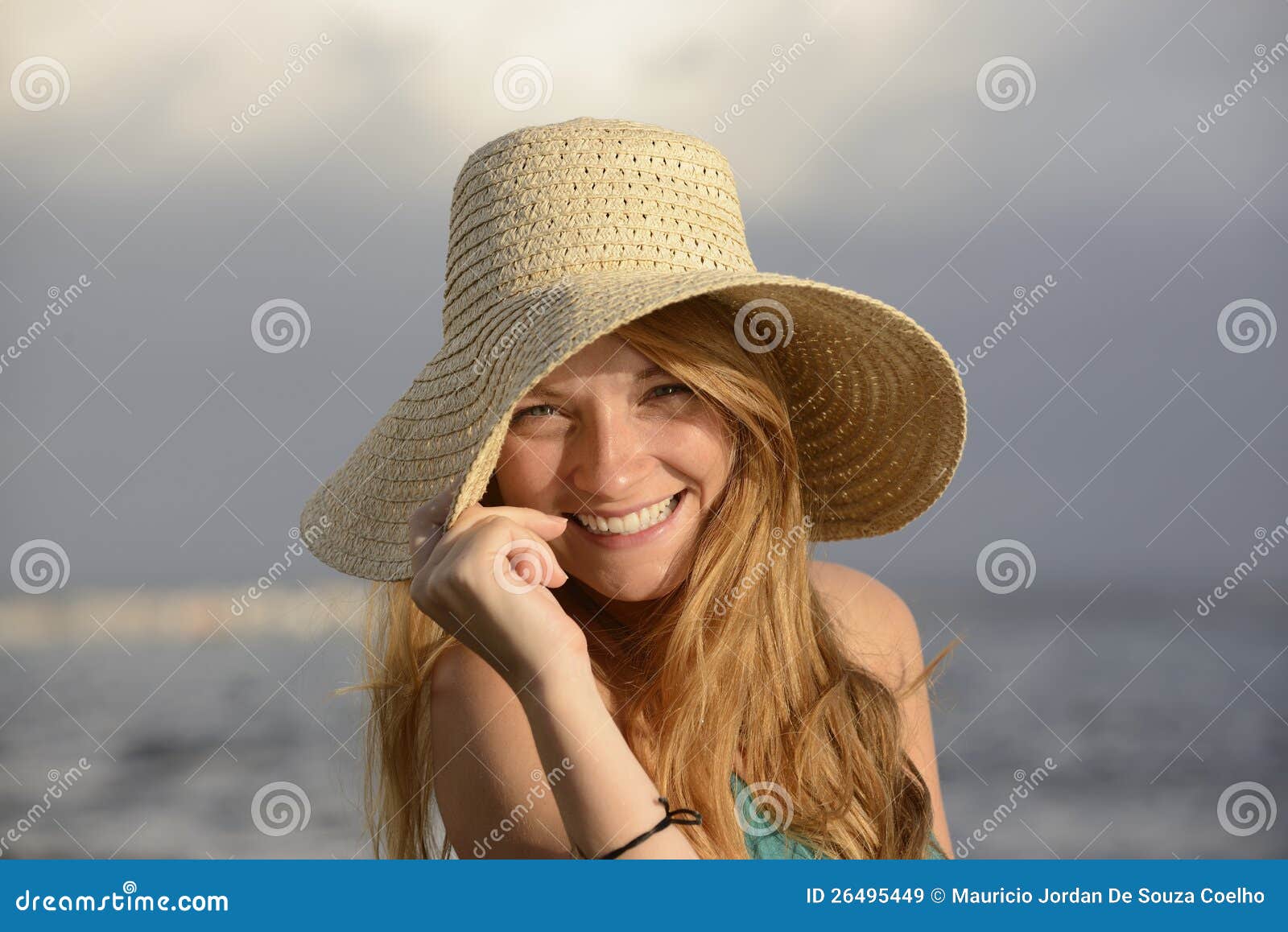 Ξανθή γυναίκα με το ψαθάκι στην παραλία. Ξανθή γυναίκα με το ψαθάκι στο γέλιο παραλιών