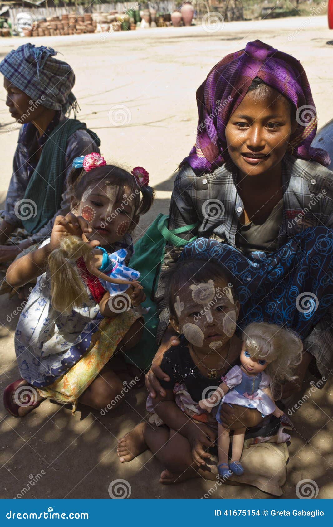 Παιδιά σε ένα χωριό στο Μιανμάρ. Ένδεια μέσω του ματιού του παιδιού Αυτές οι εικόνες έχουν λήφθουν σε ένα μικρό χωριό στο Μιανμάρ (Βιρμανία) Μια μητέρα και ο γιος δύο της, στο πρόσωπο έχουν τη χαρακτηριστική κρέμα σανδάλι-σαφρανιού για να προστατεύσουν το δέρμα από τον ήλιο Κρατούν τις κούκλες, ένα παρόν από μας