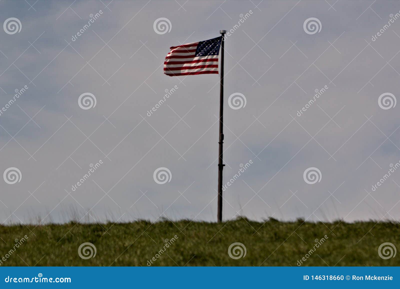 Παλαιά δόξα που πετά στο δύσκαμπτο αεράκι. Αμερικανική σημαία στον αέρα από μια πλευρά λόφων με πέρα από του χυτού ουρανού