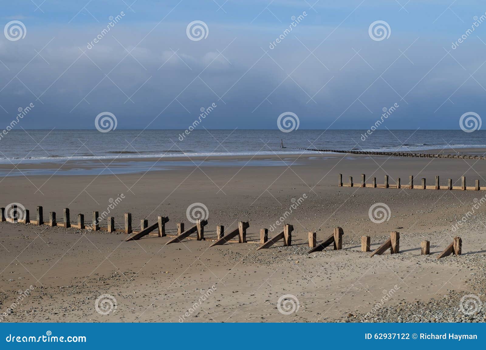 Αμμώδης παραλία με τα groynes, μια θυελλώδη ημέρα