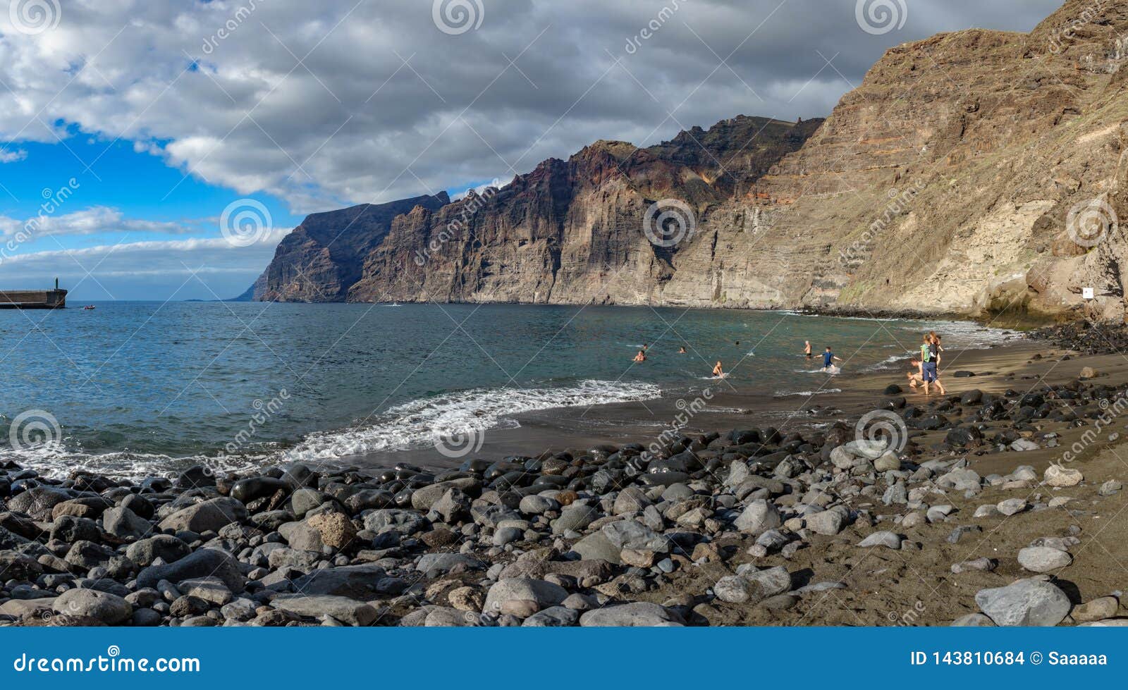 Παραλία Guios με τους απότομους βράχους Los gigantes και τους θολωμένους τουρίστες. Πανοραμική άποψη της παραλίας Guios με τους απότομους βράχους Los gigantes και τους θολωμένους τουρίστες