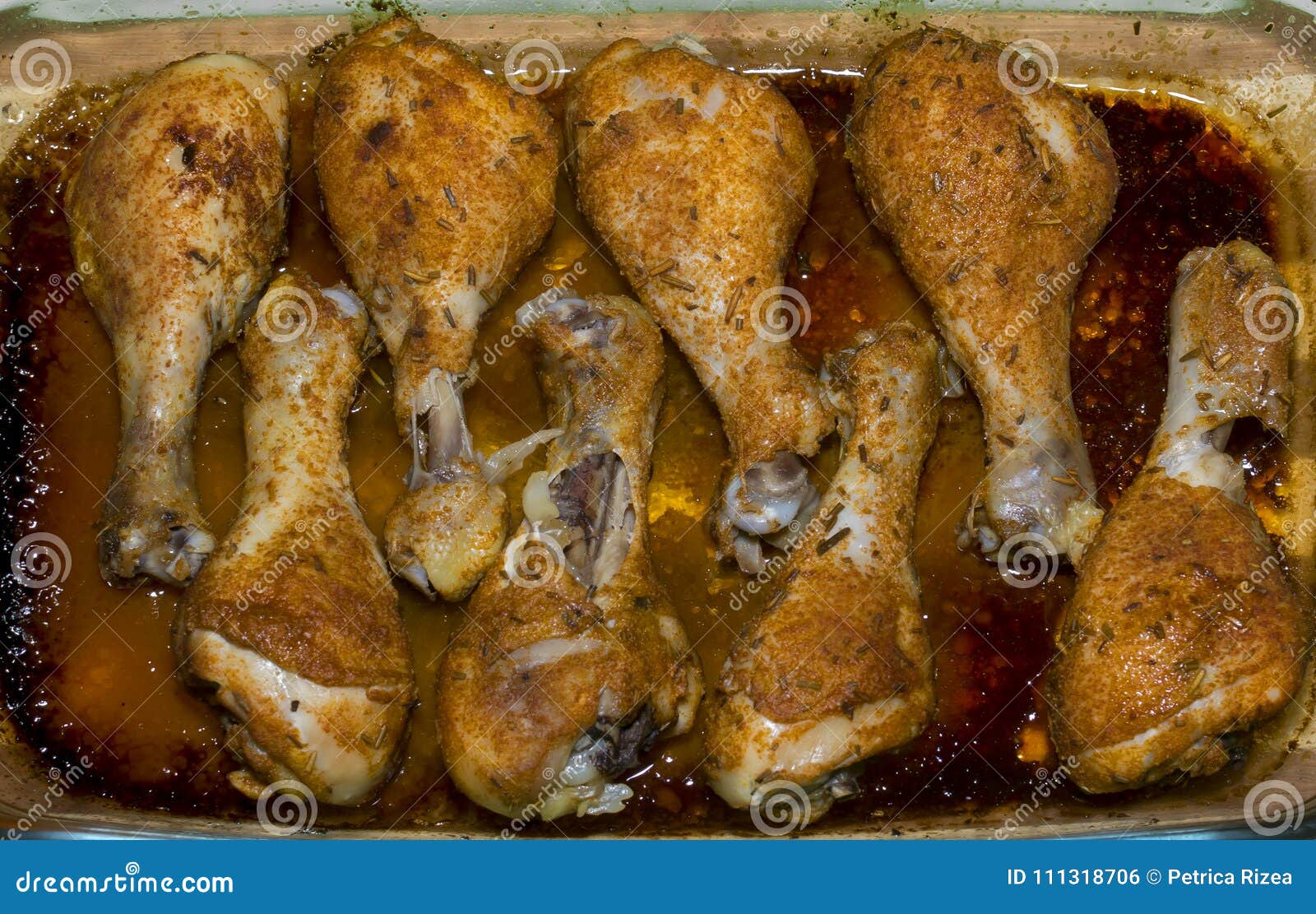 Πόδια κοτόπουλου που ψήνονται στο φούρνο. Πόδια κοτόπουλου που ψήνονται στους μηρούς κοτόπουλου φούρνων με τα καρυκεύματα