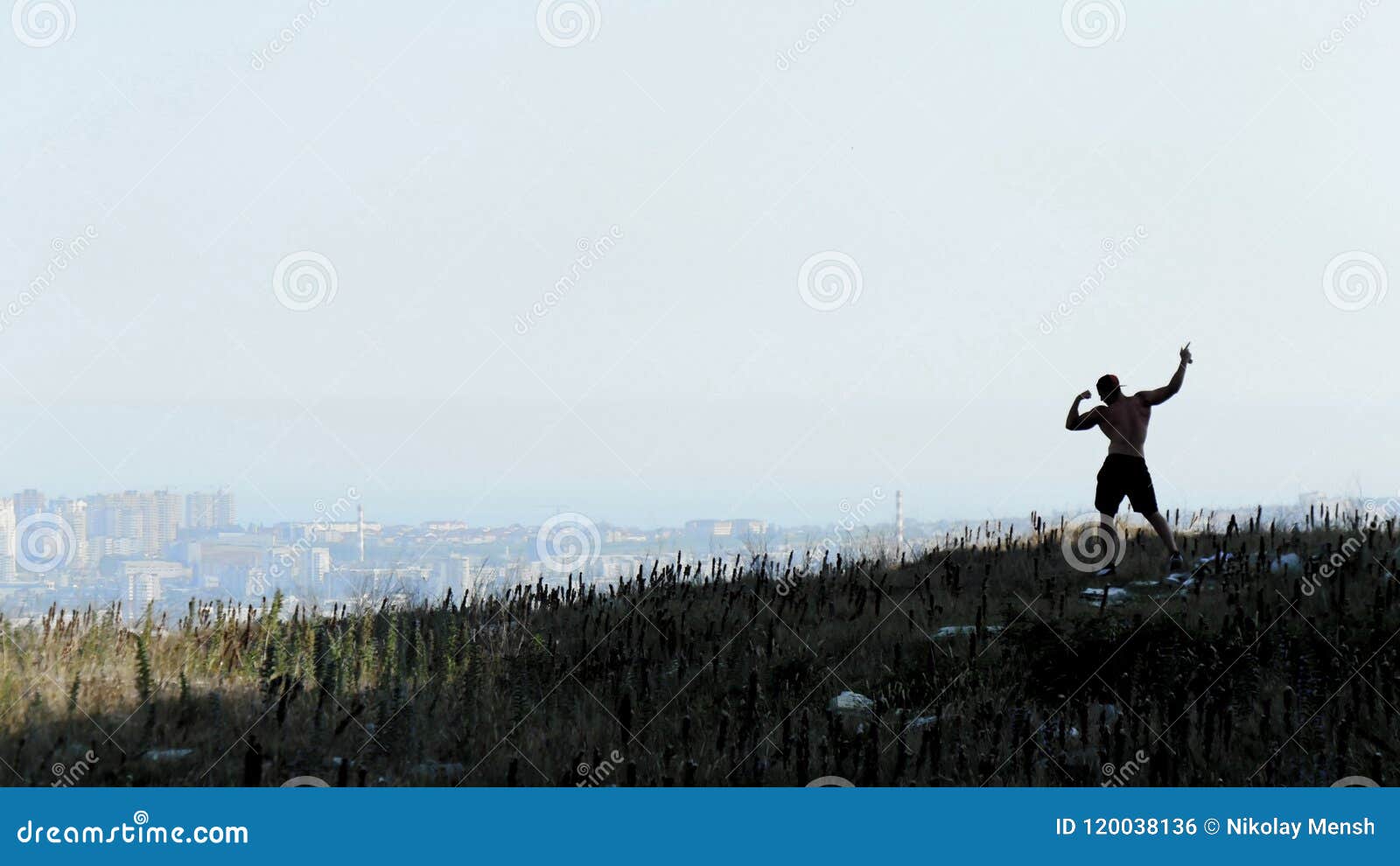 Σκιαγραφία του αθλητικού ατόμου αφροαμερικάνων με τη γυμνή τοποθέτηση κορμών στο βράχο Πόλη υποβάθρου