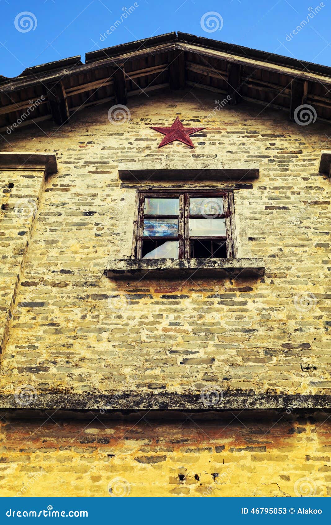 Τοίχος του σπιτιού με ένα σπασμένο παράθυρο, τοίχος του κτηρίου μείωσης ή φτωχό σπίτι. Ο παλαιός κίτρινος τουβλότοιχος του σπιτιού με ένα σπασμένο παράθυρο Ένας τοίχος του κτηρίου μείωσης ή του φτωχού σπιτιού με ένα pentagram ή αστέρι στην Κίνα Ίσως χτίζεται στο έτος της μεγάλης πολιτισμικής επανάστασης