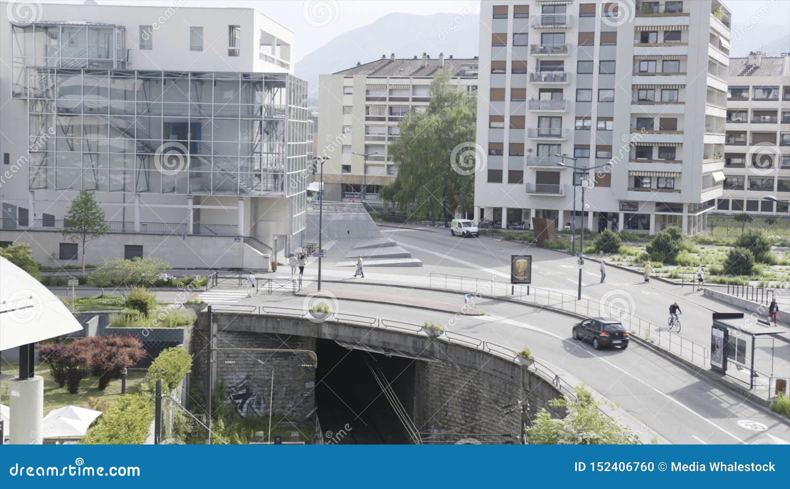 Τοπίο πόλεων με το σιδηρόδρομο που προέρχεται από υπόγειο και ένας δρόμος με να κινήσει τα αυτοκίνητα ανωτέρω r Μια οδός πόλεων μ. Τοπίο πόλεων με το σιδηρόδρομο που προέρχεται από υπόγειο και ένας δρόμος με να κινήσει τα αυτοκίνητα ανωτέρω Μια οδός πόλεων με την οδήγηση των οχημάτων, σπίτια και το περπάτημα των ανθρώπων