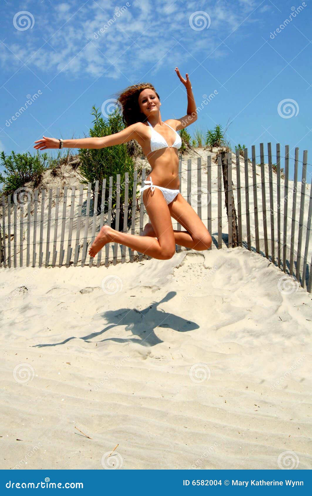 όμορφος πηδώντας έφηβος πα. όμορφο bikini παραλιών κορίτσι που πηδά το εφηβικό λευκό