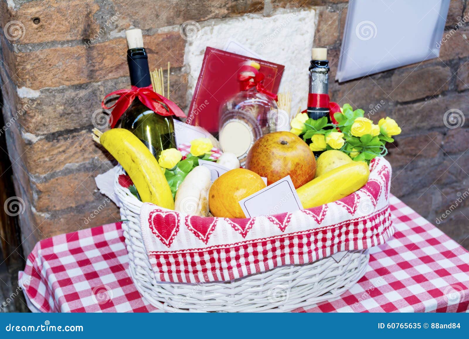 Белая корзина с плодоовощами и бутылками вина на красной Checkered ...